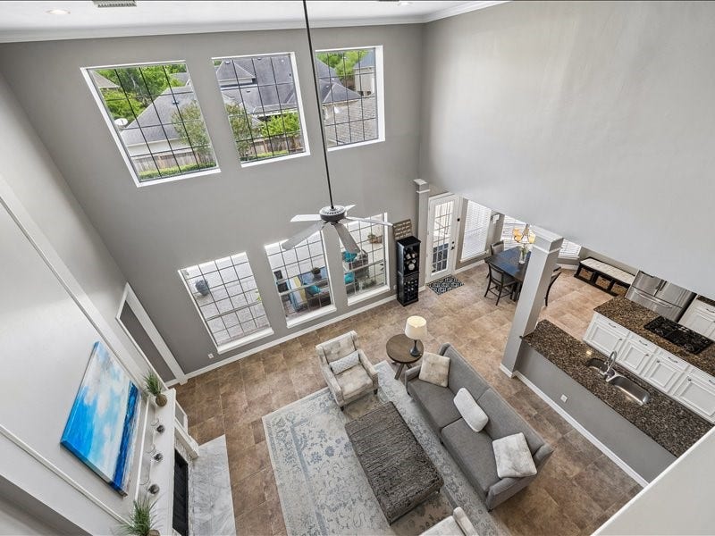 9007 Avebury Stone Circle, Missouri City, TX 77459 A stunning bird's-eye perspective from the upper landing reveals the grand scale of the main living area, open kitchen, and the home's beautifully connected layout. A true showpiece of open-plan living at its finest.