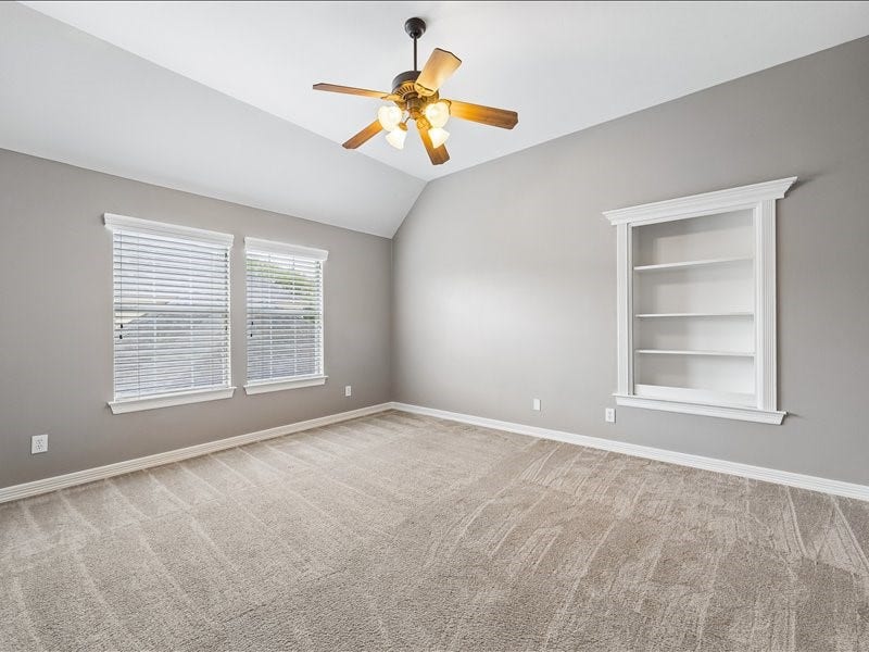 9007 Avebury Stone Circle, Missouri City, TX 77459 A freshly updated secondary bedroom with a vaulted ceiling, ceiling fan, double windows with blinds, and a charming built-in wall shelving nook but whats behind that custom bookshelf?