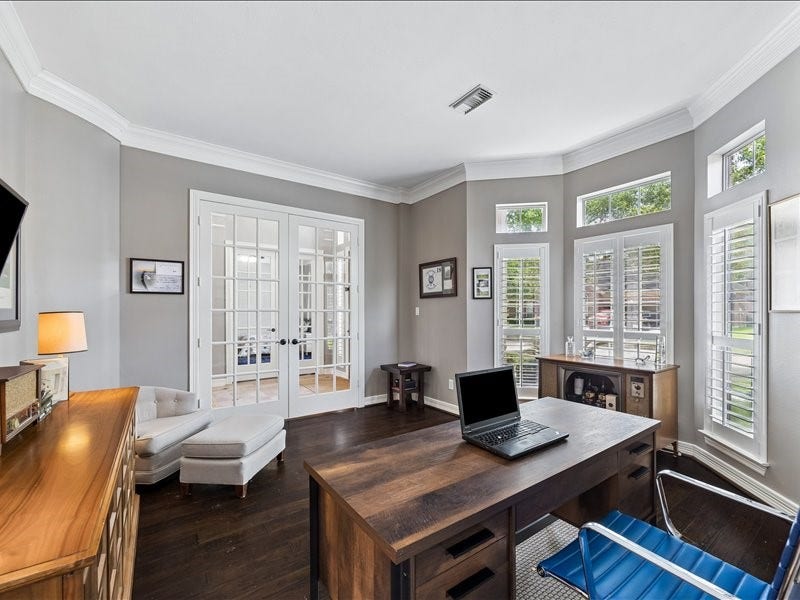 9007 Avebury Stone Circle, Missouri City, TX 77459 The study's stunning bay window floods the space with natural light and serene garden views, complemented by plantation shutters, dark hardwood floors, French doors to the foyer and ample workspace for any lifestyle.