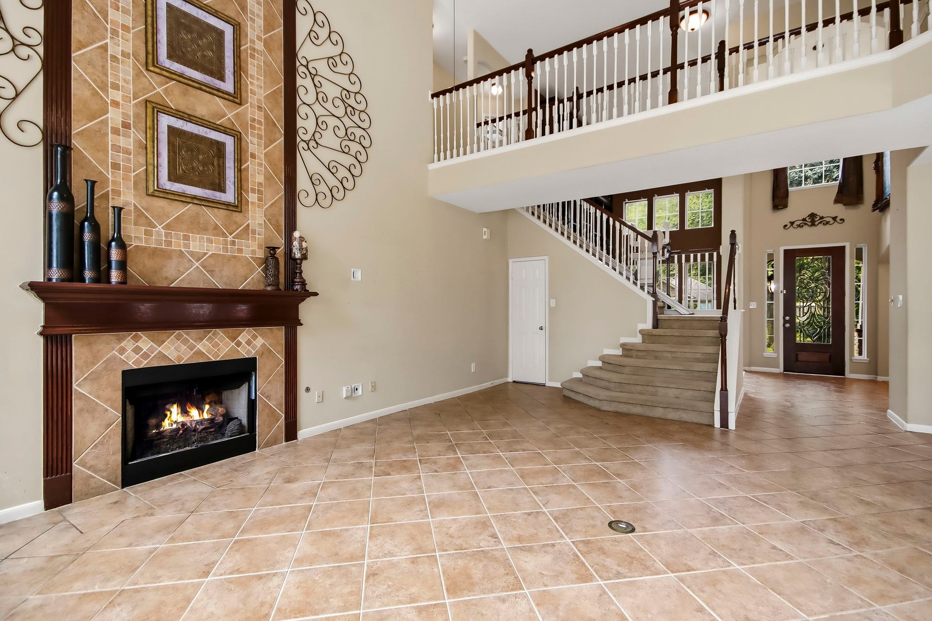 Impressive two-story living area featuring soaring ceilings, abundant natural light, and a beautiful fireplace, creating a grand yet inviting space for relaxing and entertaining.