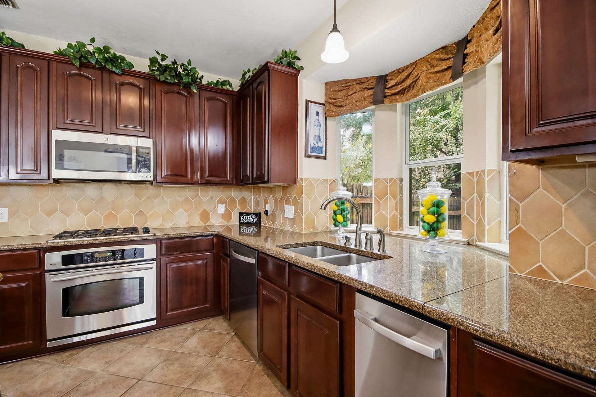 Beautiful kitchen featuring granite countertops, stainless steel appliances, and a charming window above the sink offering gorgeous outdoor views and abundant natural light.