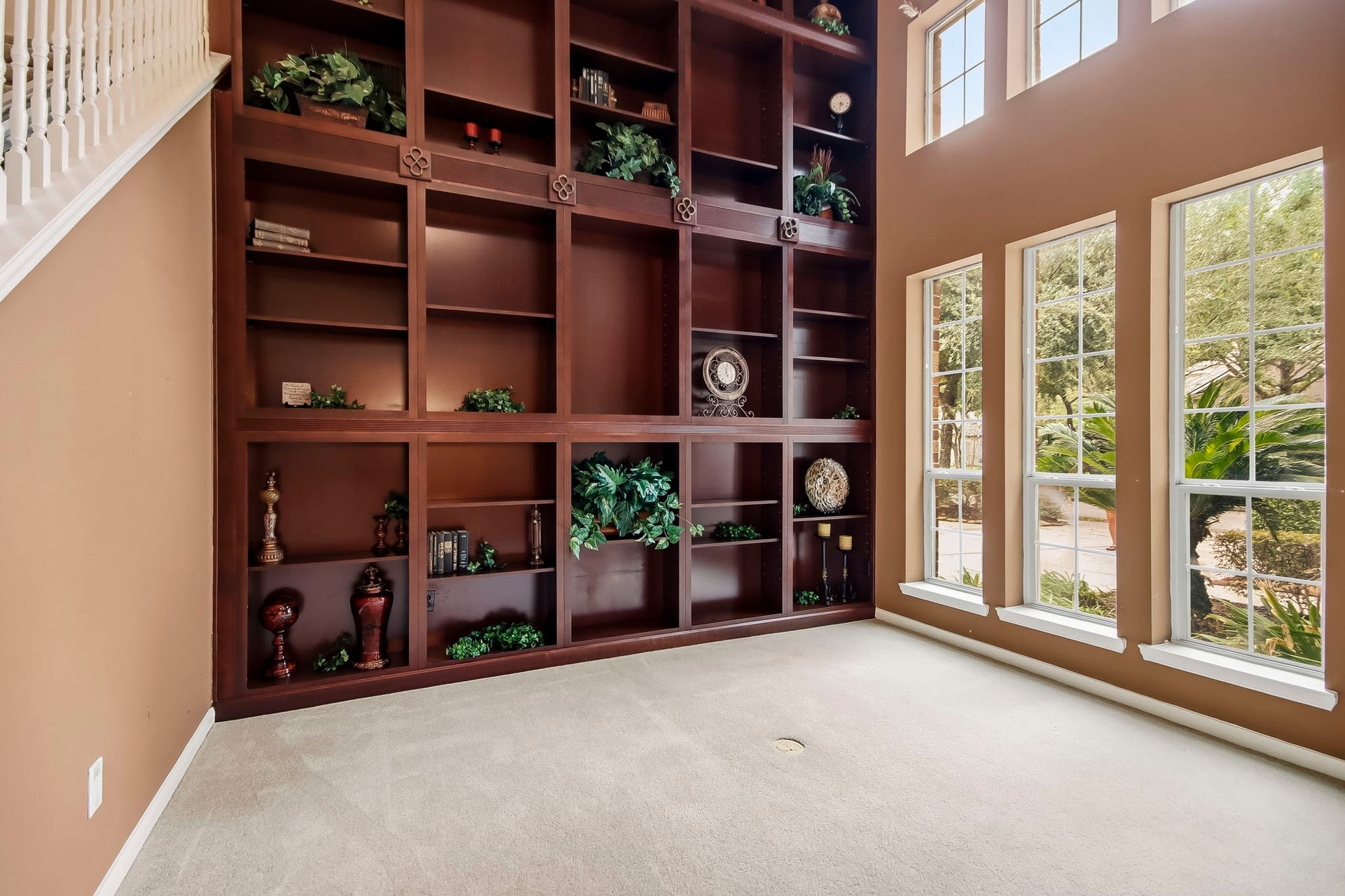 Elegant library featuring stunning floor-to-ceiling custom built-in bookshelves, offering a sophisticated space for reading, working, or relaxing.