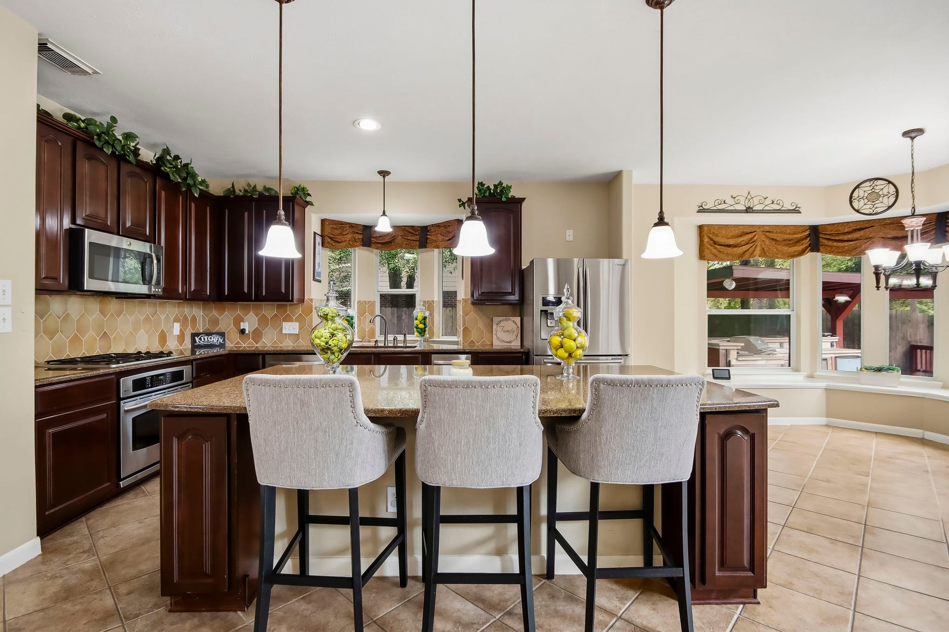 Beautiful open-concept kitchen featuring elegant pendant lighting and a seamless flow into the spacious living area and charming breakfast nook, perfect for everyday living and entertaining!