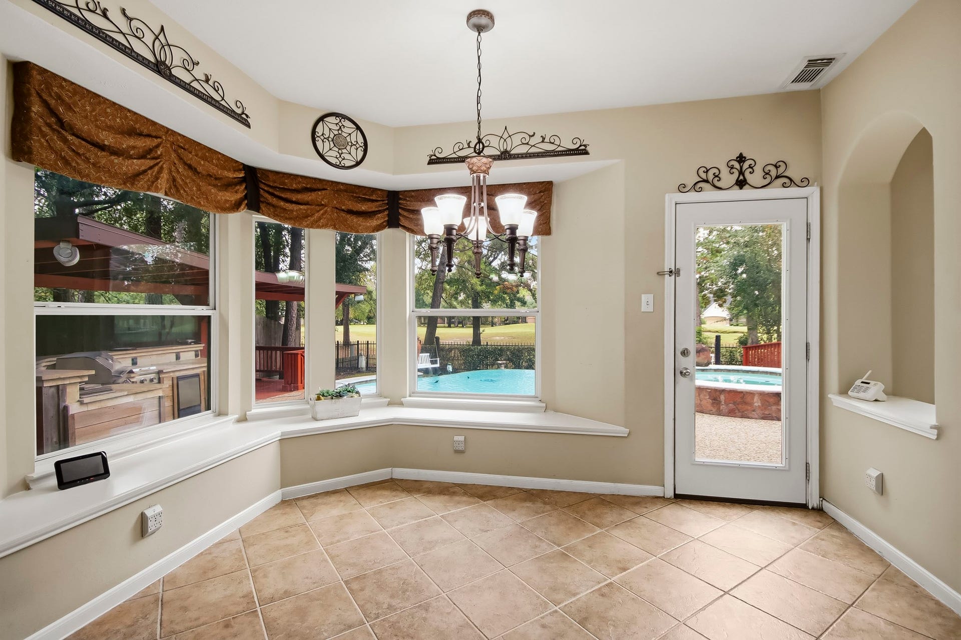 Charming kitchen nook featuring built-in seating, ready for your dining table, with beautiful views overlooking the sparkling pool. The perfect spot to enjoy your morning coffee or casual meals!
