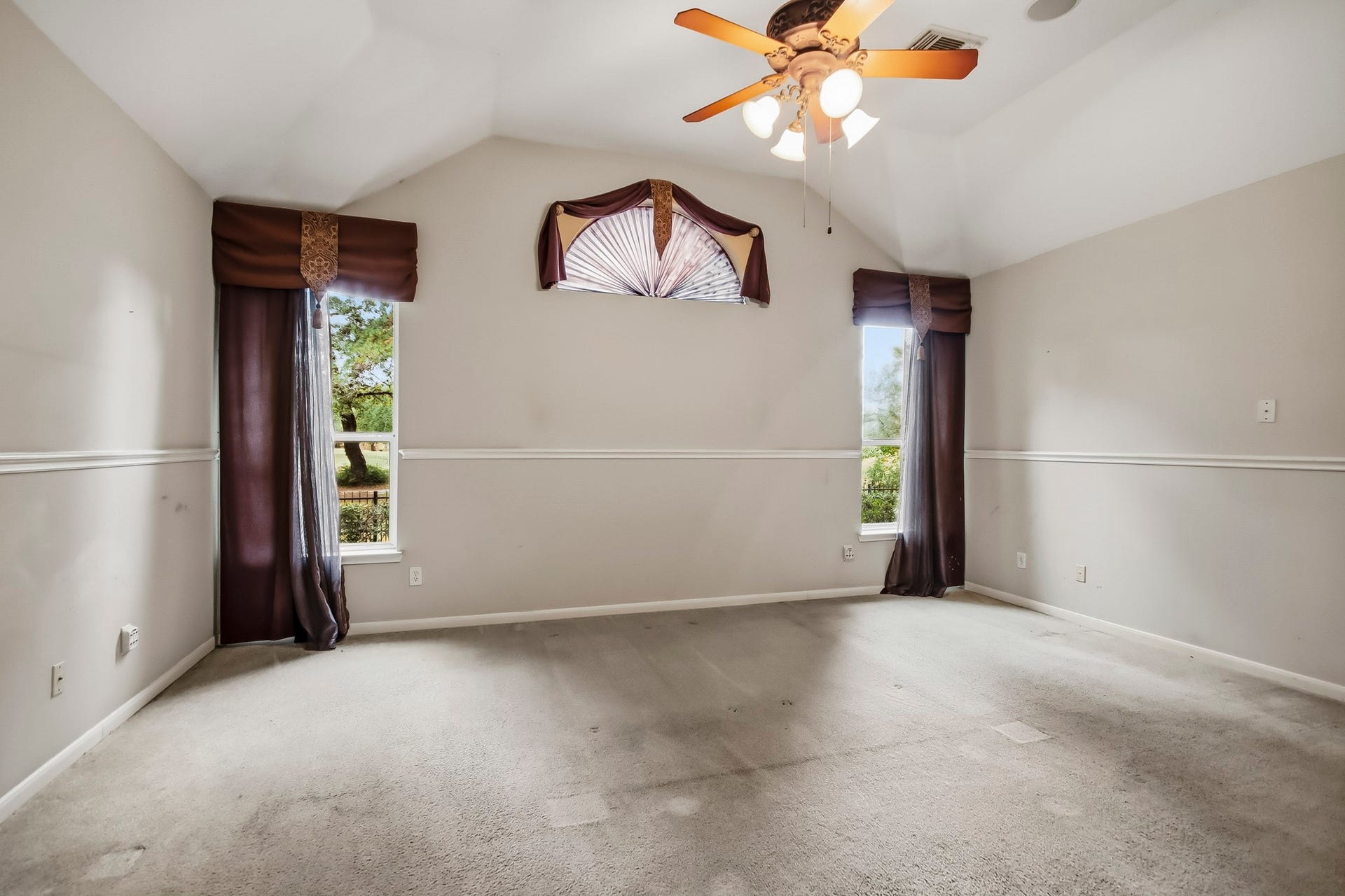 Expansive primary bedroom featuring a ceiling fan, abundant natural light, and breathtaking views of your sparkling pool and lush golf course, creating the perfect private retreat!