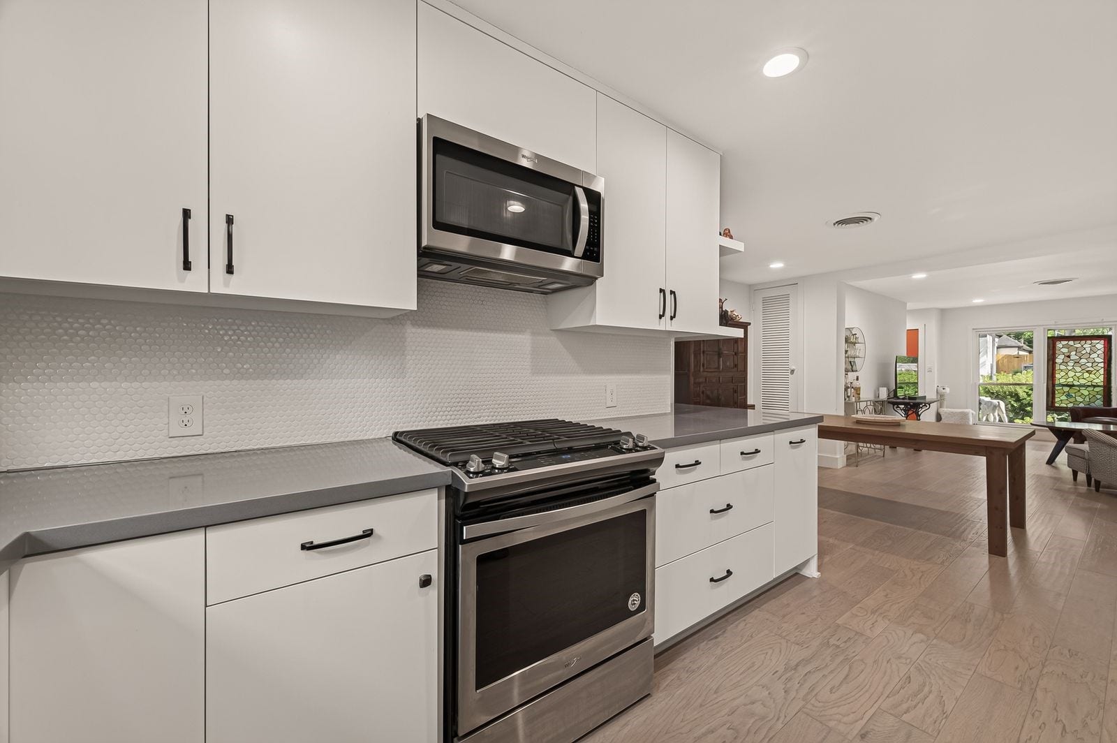 9538 Kerrwood Lane, Houston, TX 77080 The white penny tile backsplash compliments the stainless steele appliances and the soft grey countertops.