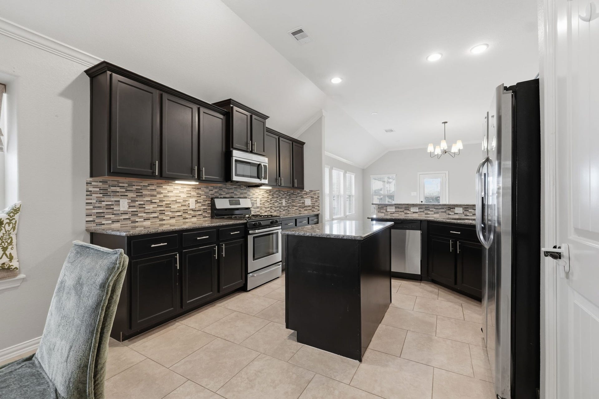 18014 Fernwood Bend Drive, Tomball, TX 77377 Spacious kitchen with island, stainless steel appliances, open to living room.