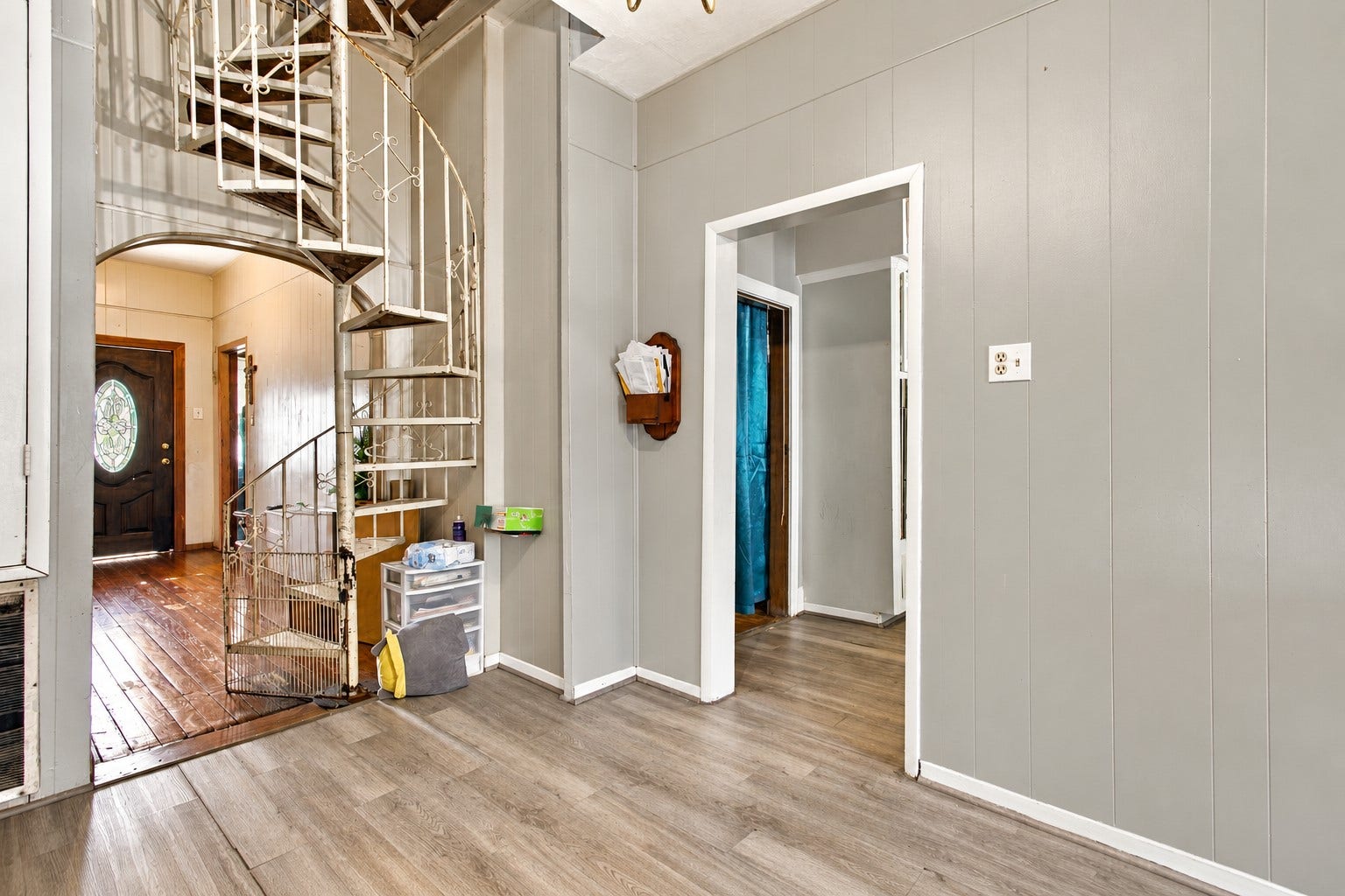 2120 Everett Street, Houston, TX 77009 Additional view of the entryway highlighting the distinctive spiral staircase, high ceilings, and connected interior spaces.