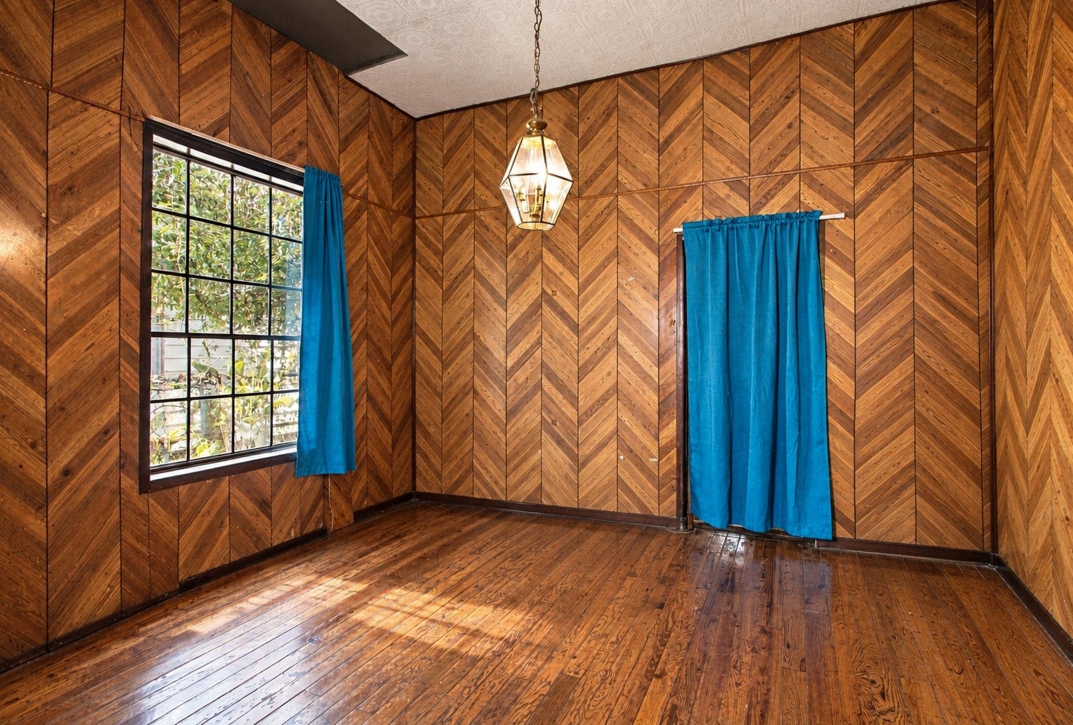 2120 Everett Street, Houston, TX 77009 Interior room featuring distinctive chevron-patterned paneling, wood flooring, and natural light.