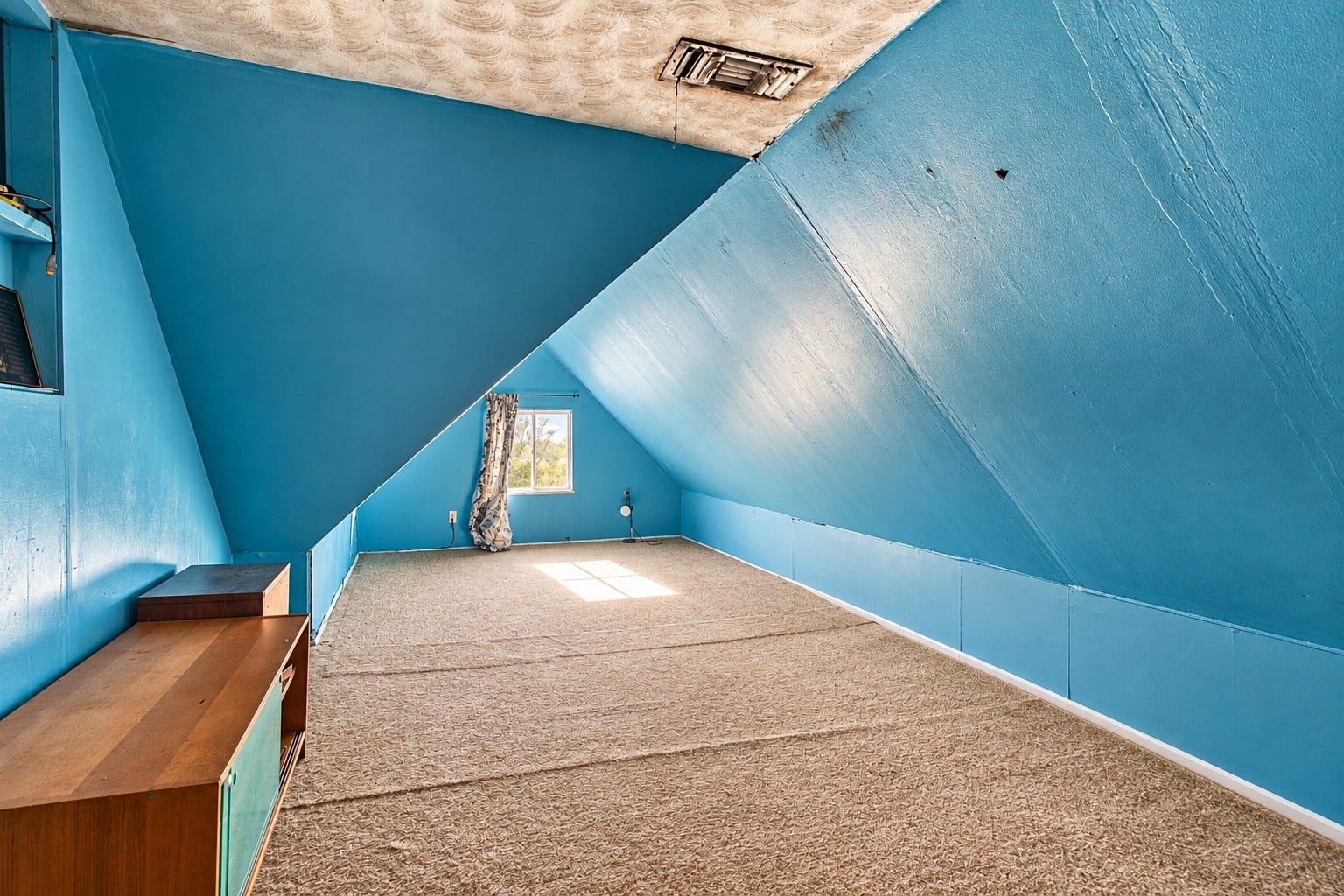 2120 Everett Street, Houston, TX 77009 One angle of the upstairs space, featuring sloped ceilings, a window, and carpeted flooring throughout the majority of the upstairs space. Please refer to the floor plan for the complete upstairs layout.