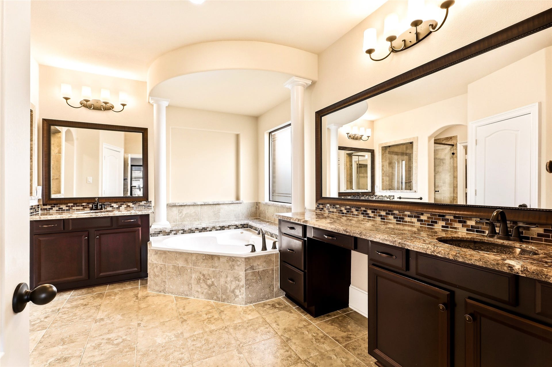 Classy primary bathroom with framed mirrors,  dual sinks, and extra vanity space