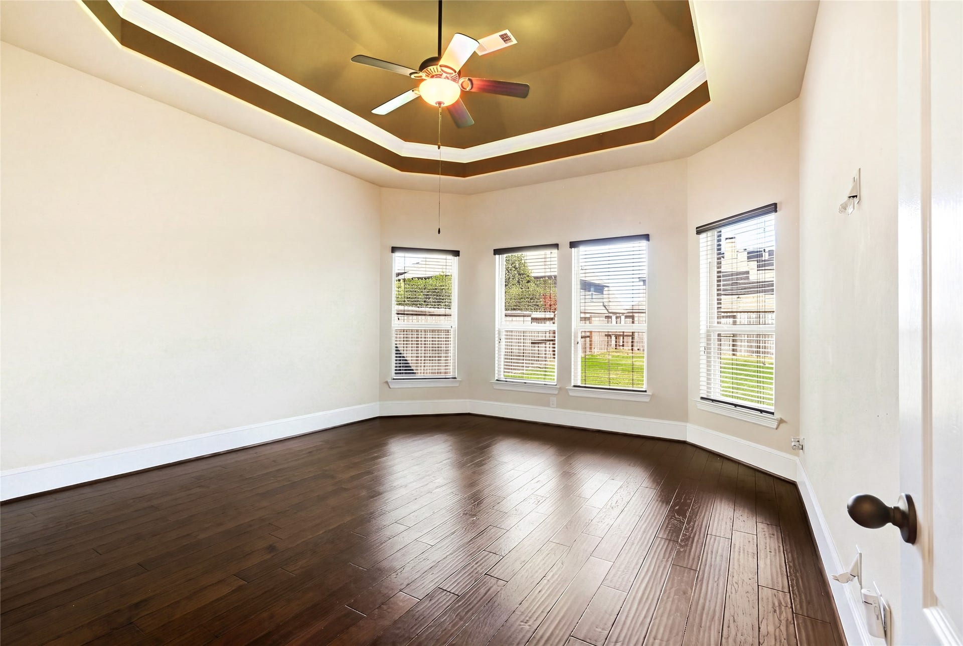 Luxurious primary bedroom with soaring tray ceiling