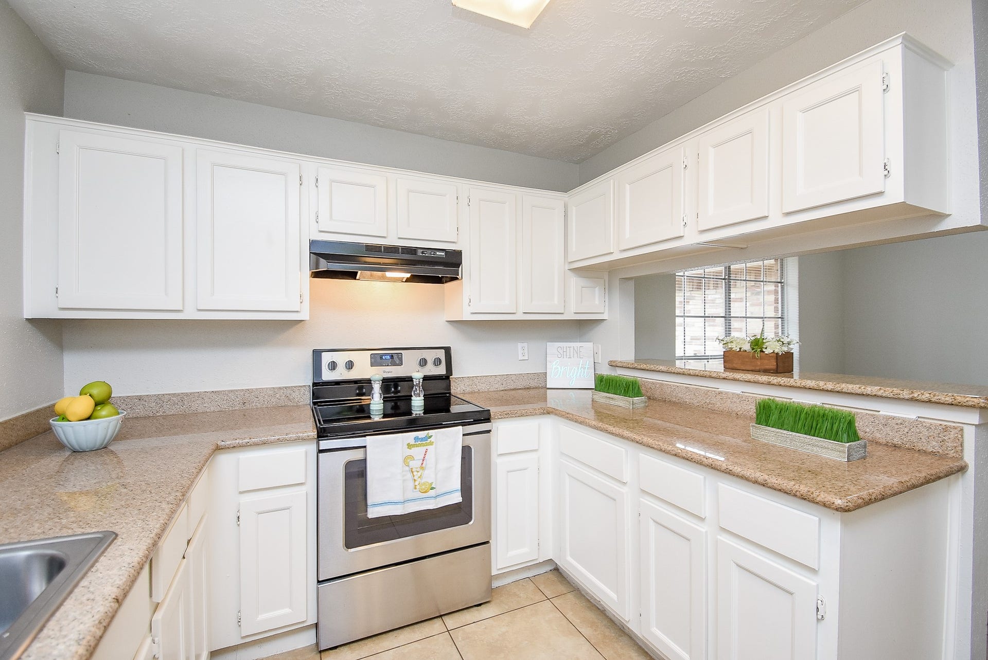 16806 Red Gully Drive, Sugar Land, TX 77498 Bright and welcoming kitchen with ample white cabinetry, modern appliances, and spacious countertops. Features a cozy breakfast bar and natural lighting.