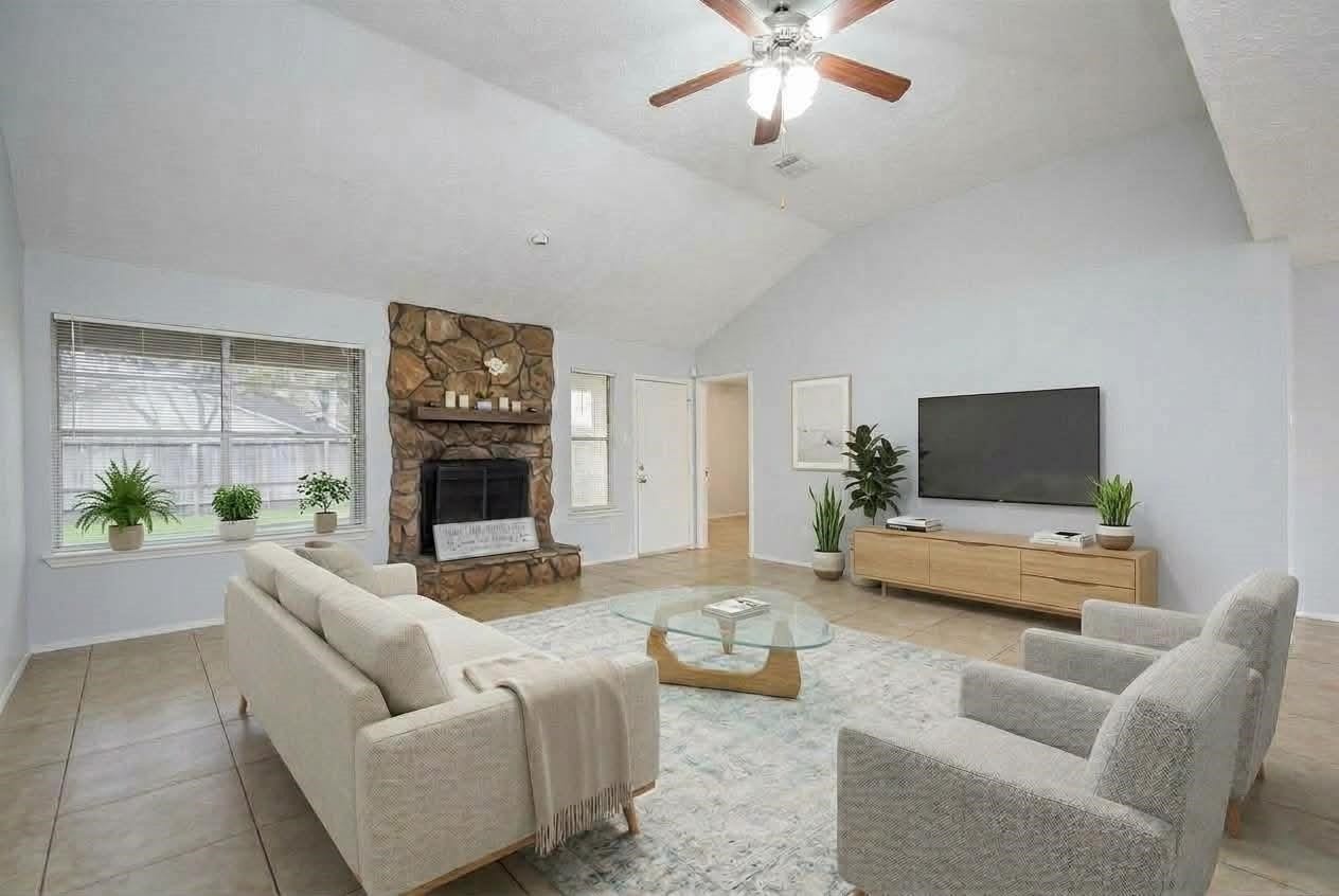 16806 Red Gully Drive, Sugar Land, TX 77498 virtual staged : This spacious living room features the neutral tones and tile flooring create a warm, inviting atmosphere.