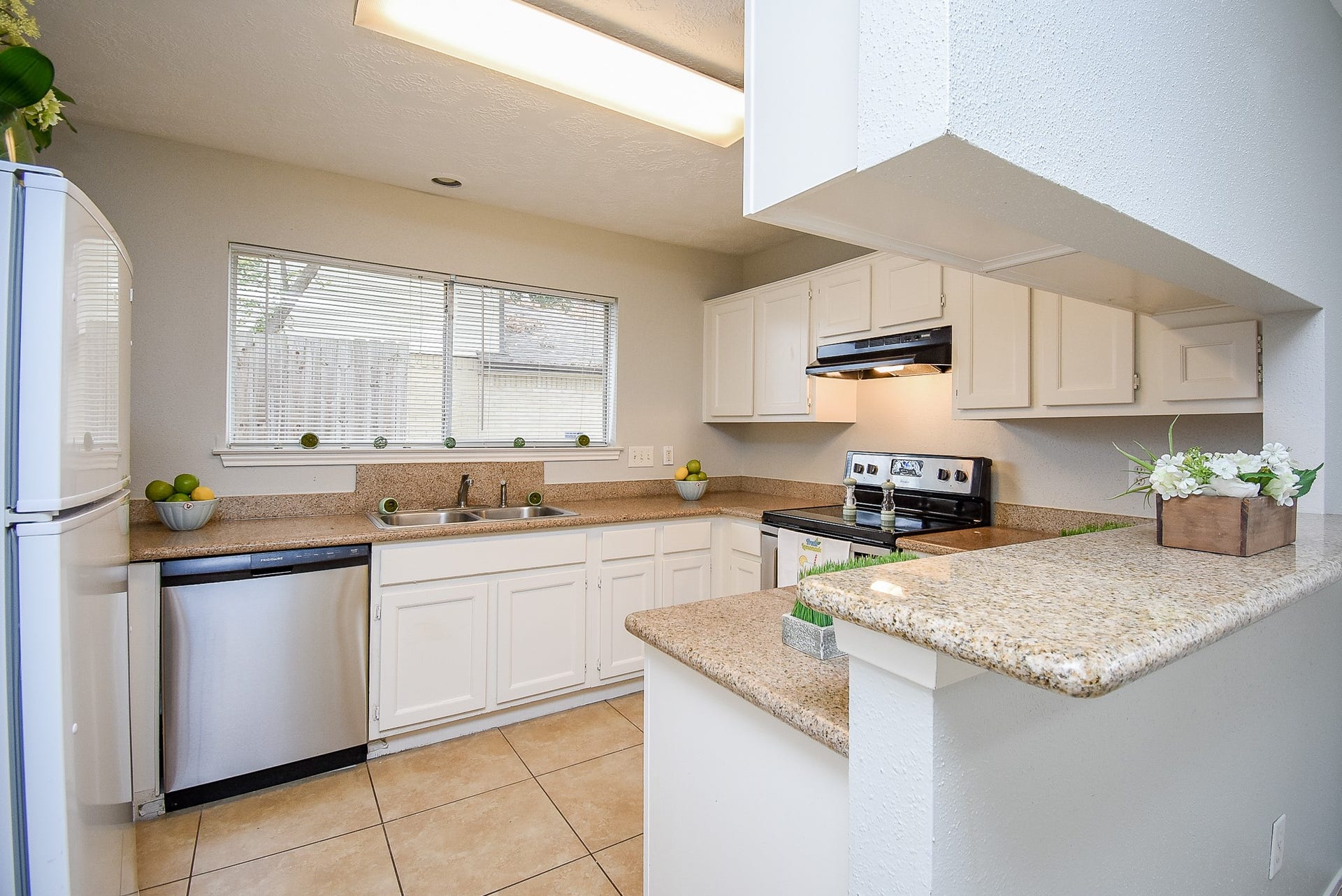 16806 Red Gully Drive, Sugar Land, TX 77498 Bright kitchen with ample natural light, featuring modern appliances, granite countertops, and white cabinetry. The open layout offers a cozy and functional space.