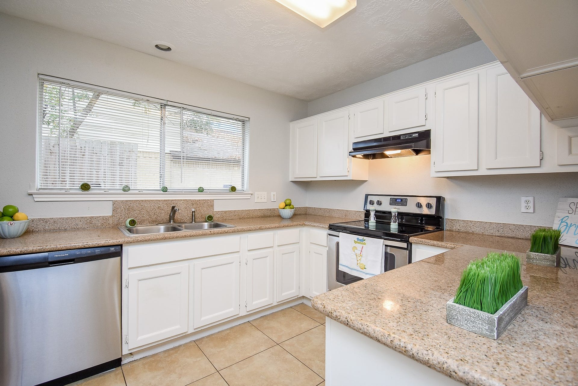 16806 Red Gully Drive, Sugar Land, TX 77498 Bright kitchen with ample natural light, featuring white cabinetry, granite countertops, stainless steel appliances, and a modern backsplash. Perfect for cooking and entertaining.