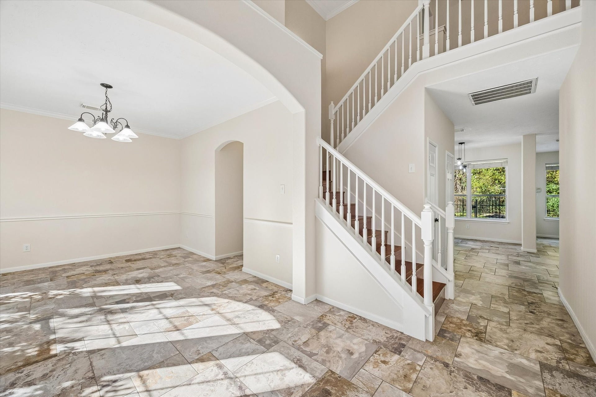 11 Merryvale Drive, The Woodlands, TX 77382 This view of the entry is perfect! The open staircase and arched doorway add architectural charm, while the open layout creates a natural flow throughout the home.
