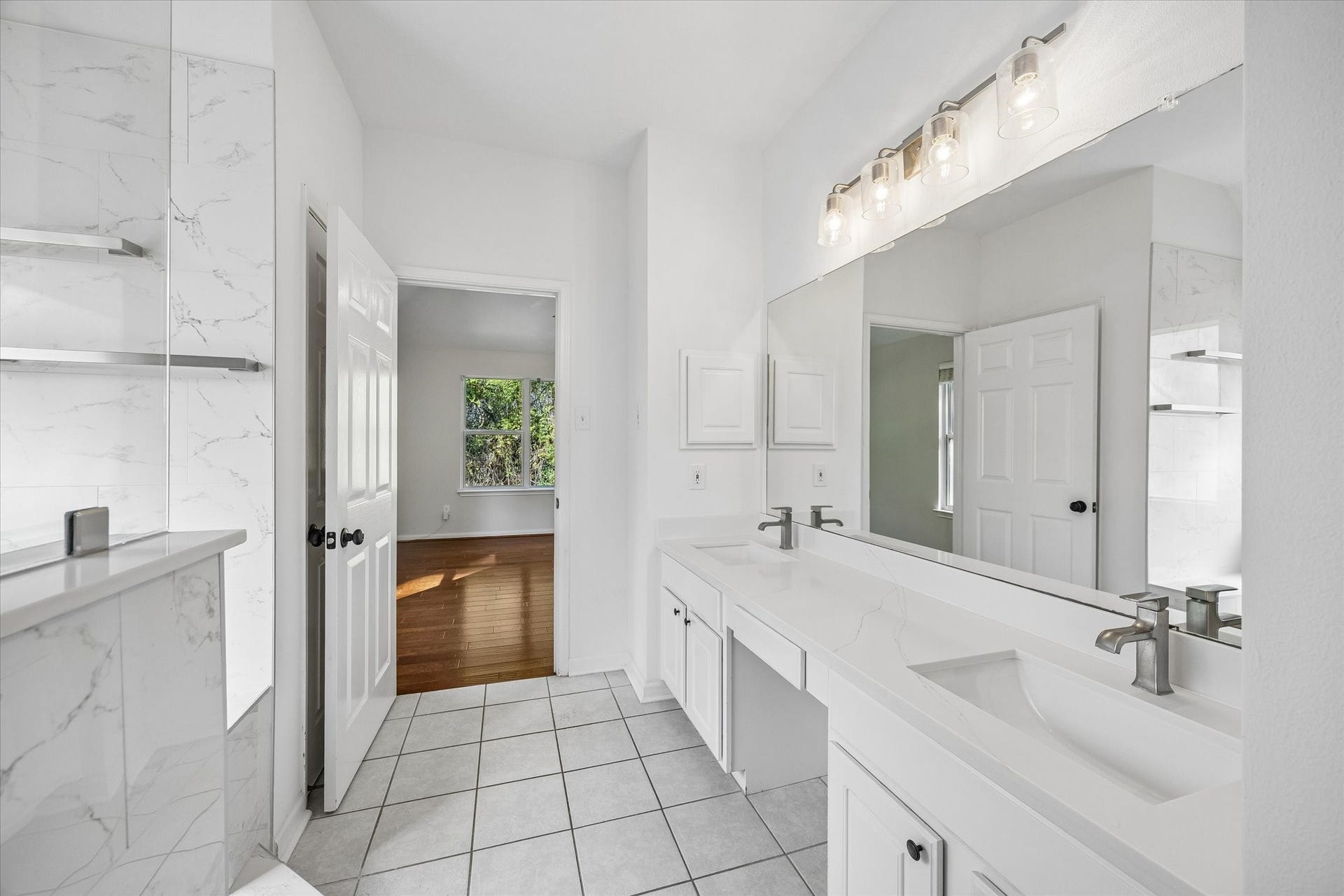 11 Merryvale Drive, The Woodlands, TX 77382 Another view of the primary en-suite bathroom, where the designer lighting adds the perfect finishing touch to this space.