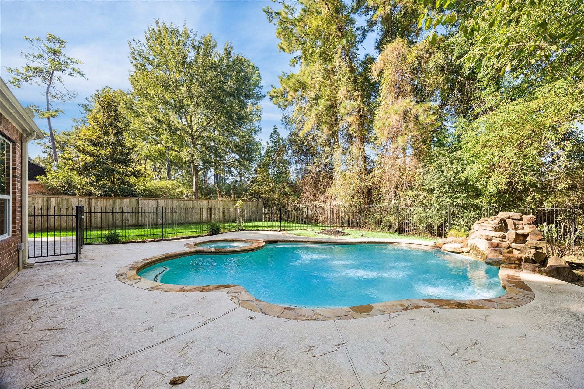 11 Merryvale Drive, The Woodlands, TX 77382 Decorative rock features add a natural, eye-catching accent to the pool area, enhancing the backyards overall appeal.