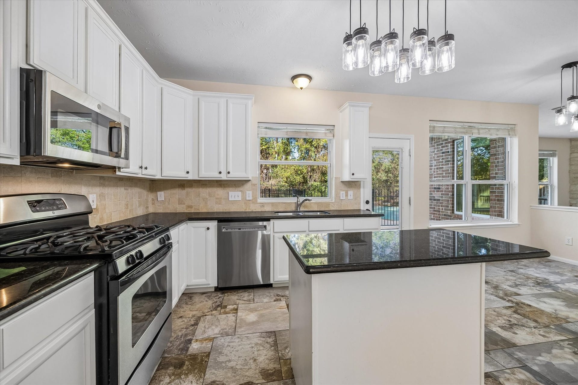 11 Merryvale Drive, The Woodlands, TX 77382 The kitchen features a double-basin sink positioned beneath a window overlooking the backyard, bringing in natural light and beautiful outdoor views. Don't miss the huge pantry!