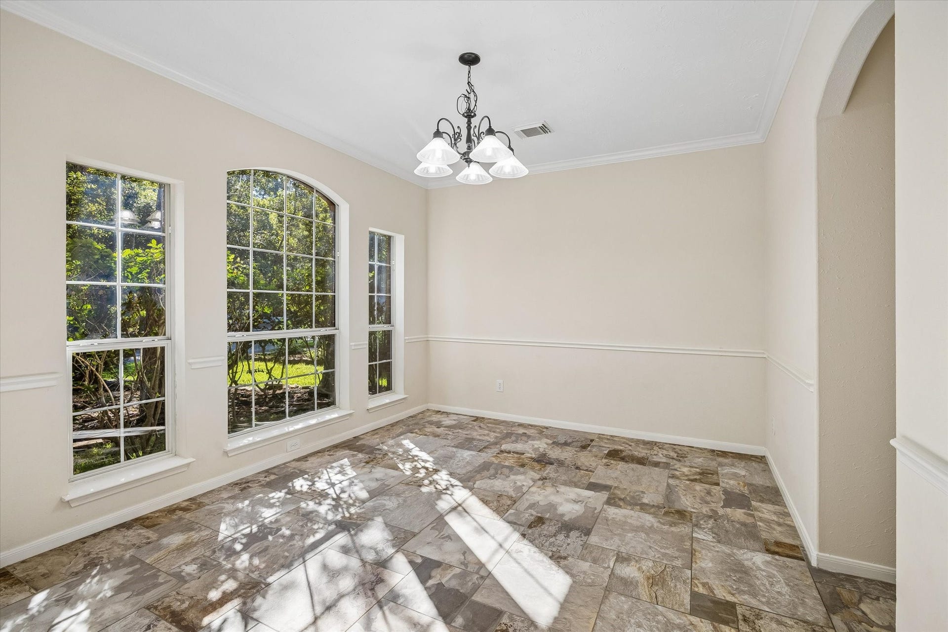 11 Merryvale Drive, The Woodlands, TX 77382 Elegant formal dining room featuring beautiful arched windows and decorative wall molding. A timeless space perfect for hosting memorable dinners and gathering with family and friends.