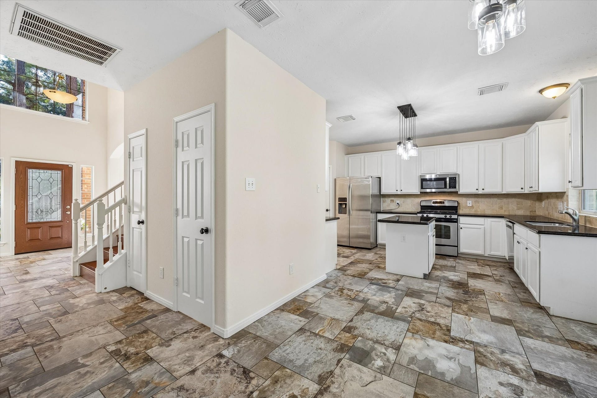 11 Merryvale Drive, The Woodlands, TX 77382 The thoughtfully designed layout allows the kitchen to flow effortlessly into the living space, while a conveniently located powder bath and additional storage closet sit just off the entryway for added functionality.