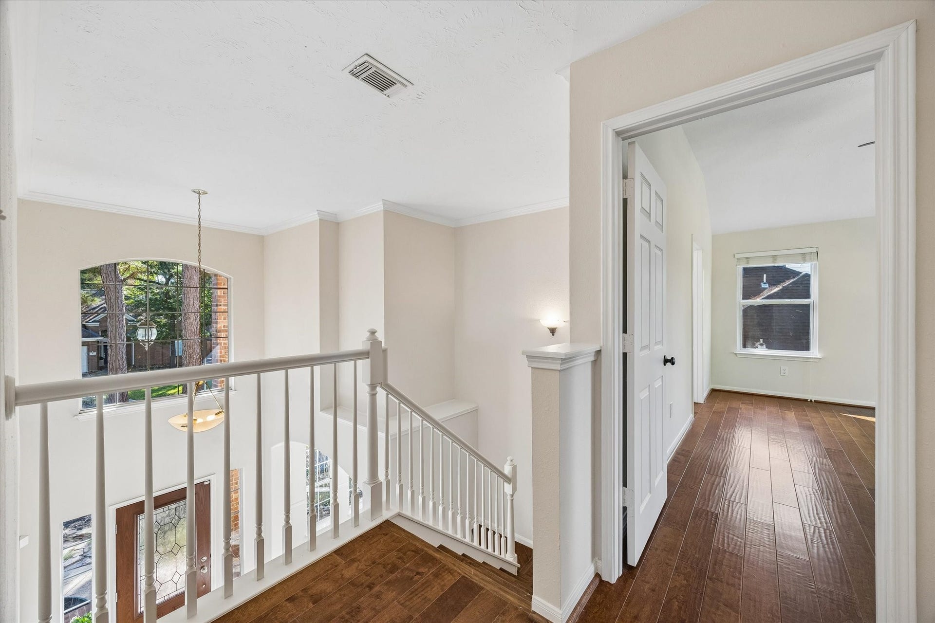 11 Merryvale Drive, The Woodlands, TX 77382 The upstairs landing overlooks the entryway below, creating an open, airy feel, while the warm wood flooring continues down the hallway to the secondary bedrooms.