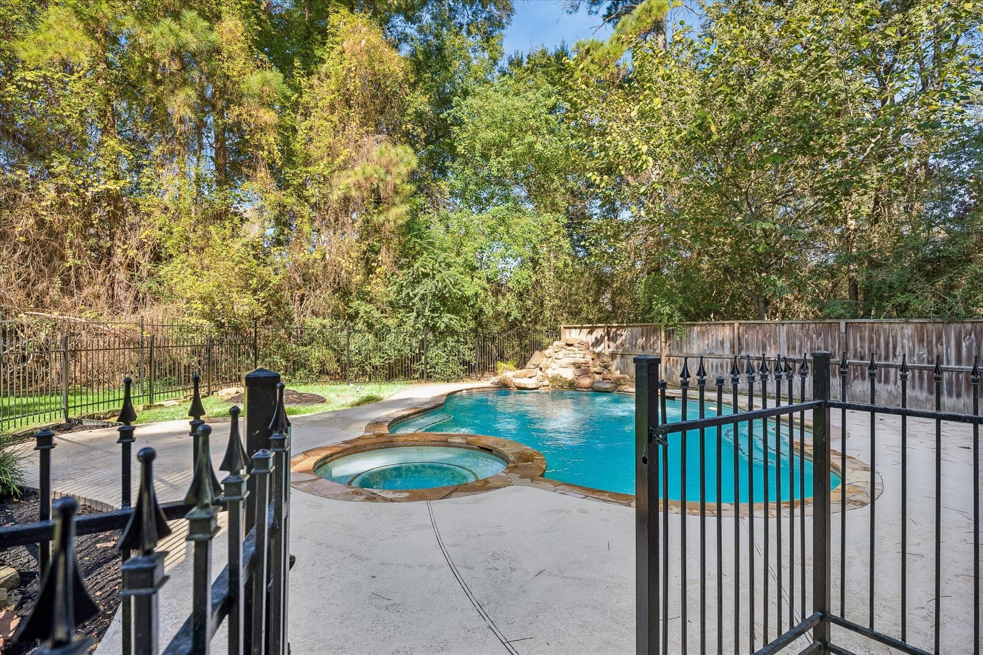 11 Merryvale Drive, The Woodlands, TX 77382 The fully fenced backyard offers added privacy, with a wrought-iron pool fence surrounding the sparkling pool and spa.
