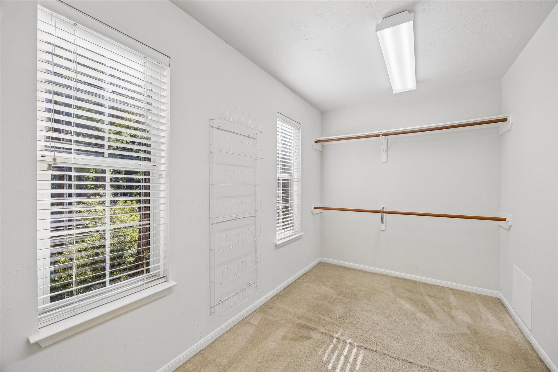 11 Merryvale Drive, The Woodlands, TX 77382 The spacious walk-in primary closet is conveniently located through the en-suite bathroom and features ample hanging space, built-in storage, and natural light.