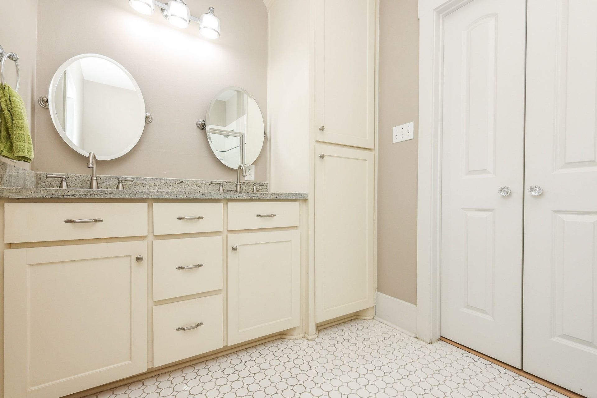 1307 Walton Street, Houston, TX 77009 Bathroom with a double vanity with undermount sinks, a large mirror, and dual wall-mounted light fixtures.