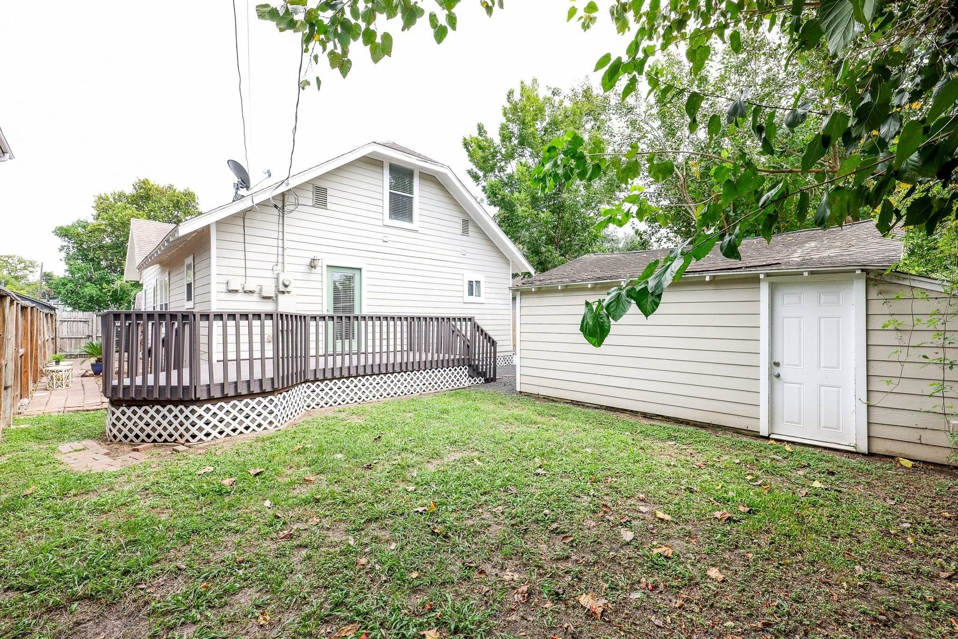 1307 Walton Street, Houston, TX 77009 Fenced backyard with a spacious grassy lawn and wood deck.