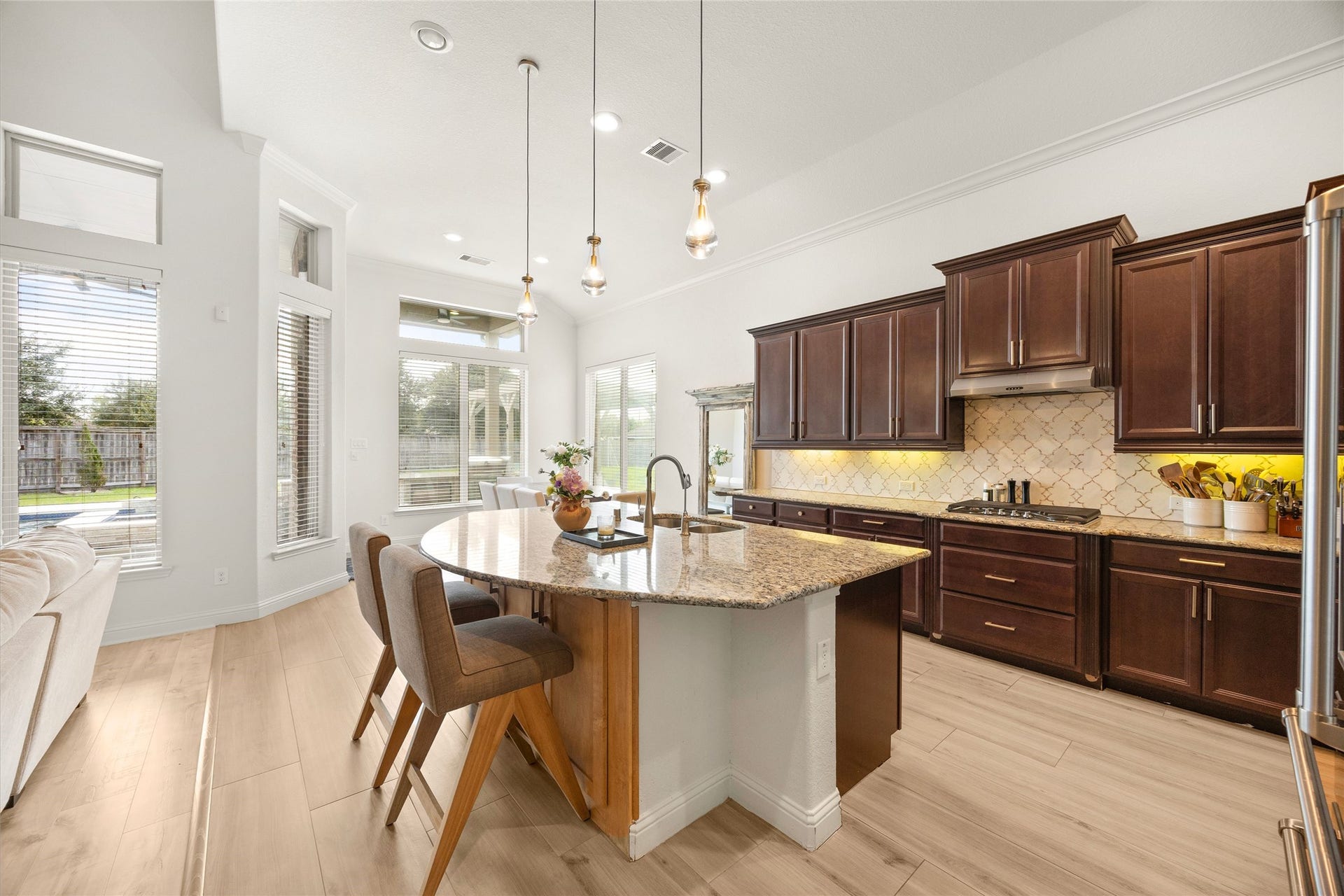 9612 Eden Ridge Lane, Pearland, TX 77584 KITCHEN II Another perspective of the kitchen highlighting the expansive island, pendant lighting, generous workspace, and open connection to the breakfast area and living room.