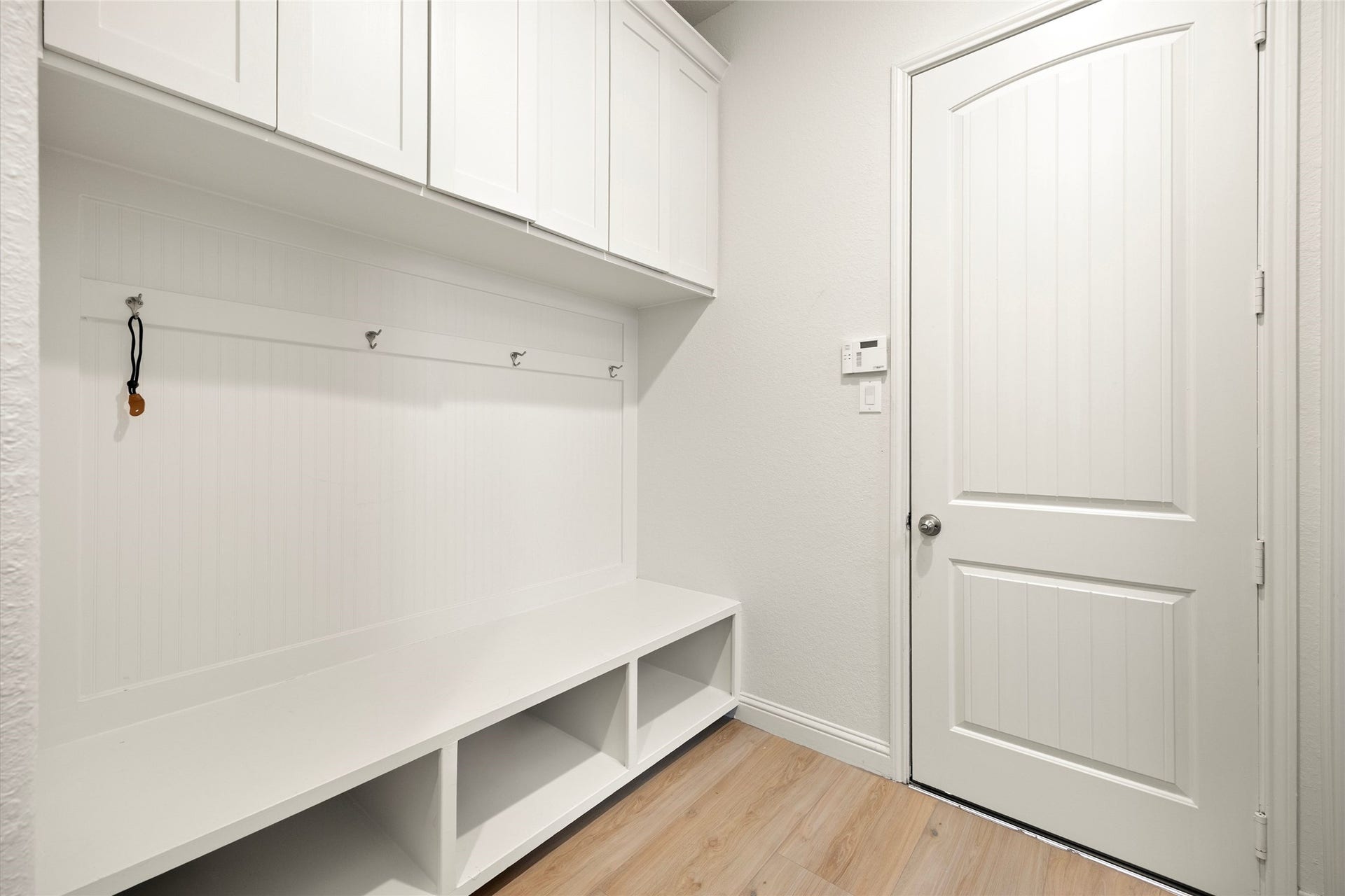 9612 Eden Ridge Lane, Pearland, TX 77584 MUDROOM Functional mudroom featuring custom built-in cabinetry, bench seating, storage cubbies, and hooks conveniently located near the garage entry.