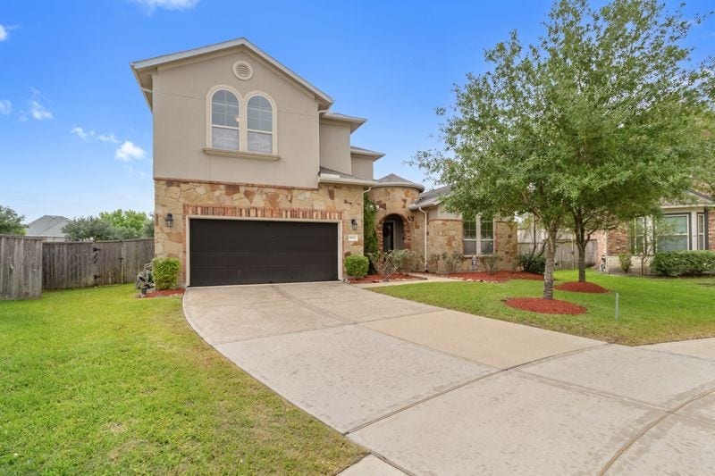 9612 Eden Ridge Lane, Pearland, TX 77584 A beautiful Mediterranean inspired home. Please note the garage door has been painted beige.
