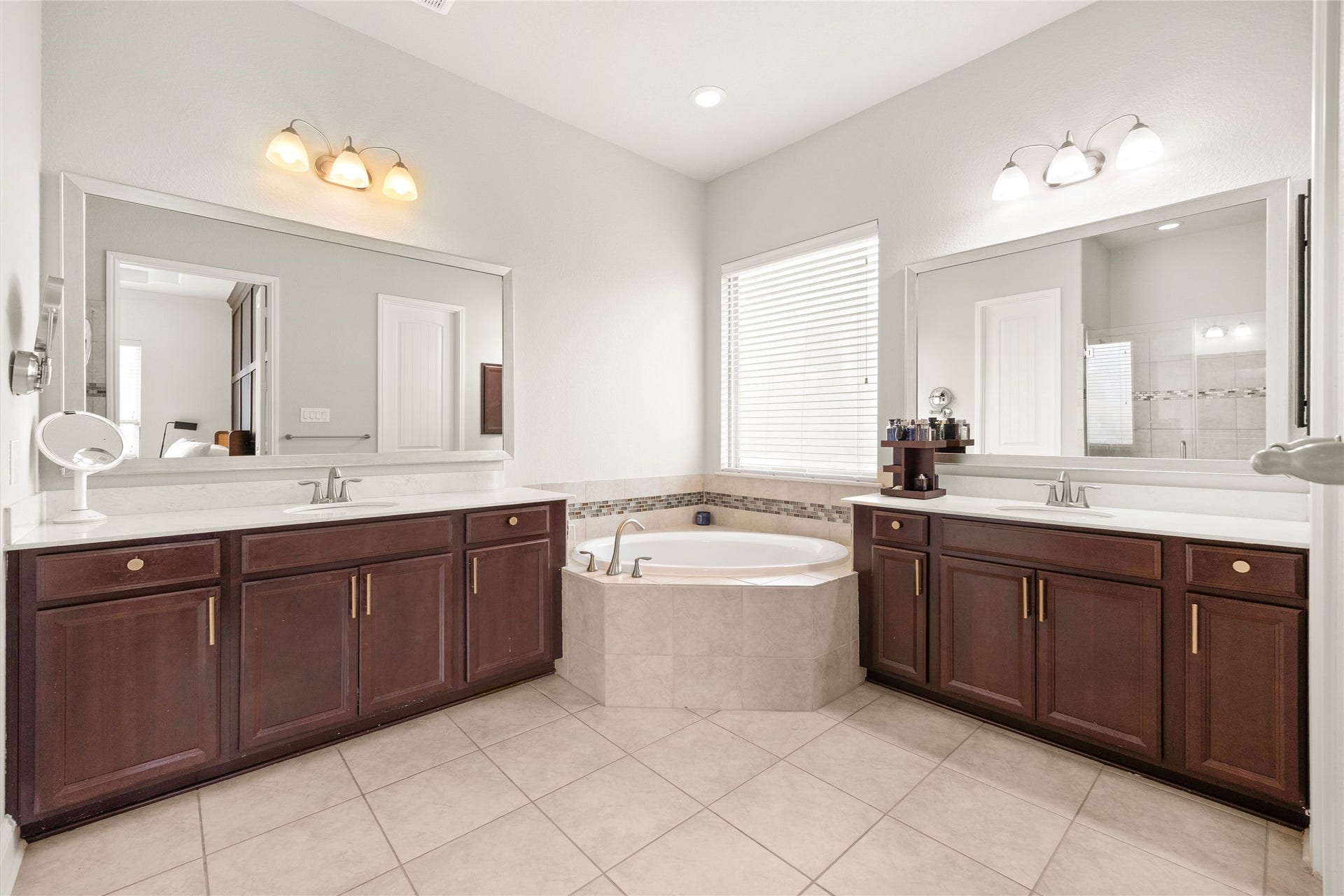 9612 Eden Ridge Lane, Pearland, TX 77584 PRIMARY BATH II Spacious en-suite bath featuring dual vanities, generous counter space, a corner soaking tub, and abundant natural light.