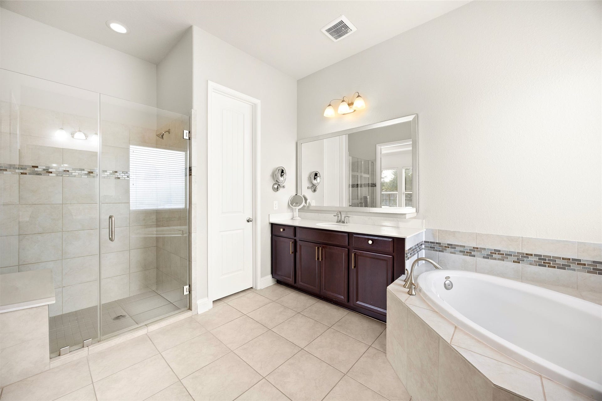 9612 Eden Ridge Lane, Pearland, TX 77584 PRIMARY BATH II Primary bath offers a separate glass-enclosed walk-in shower, soaking tub, and ample storage.