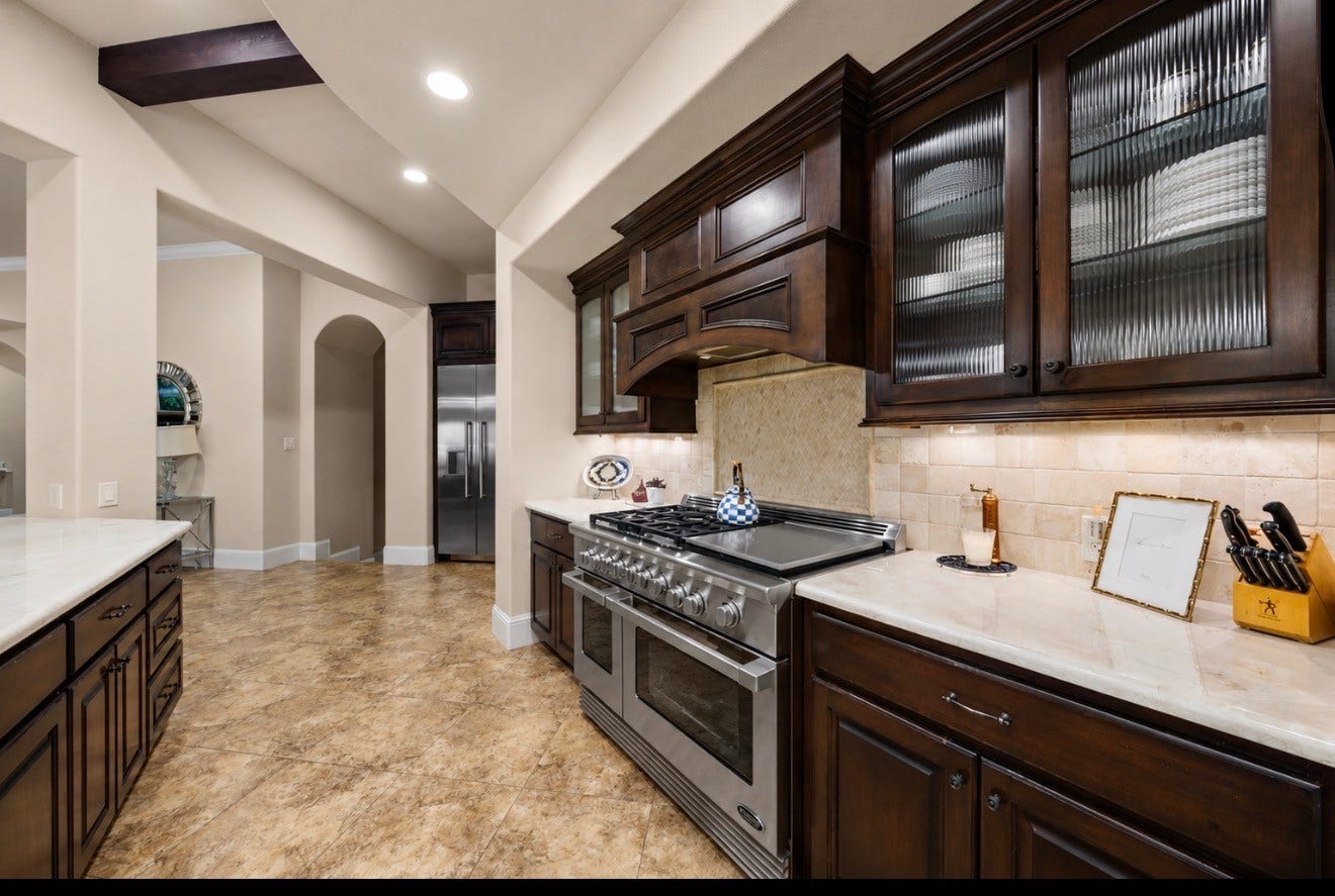 4426 Silver Jade Drive, Spring, TX 77386 Cook in absolute luxury. This high-end cooking station pairs the power of a commercial-grade DCS double-oven range with tumbled stone backsplash, perfectly illuminated by warm undermount lighting.