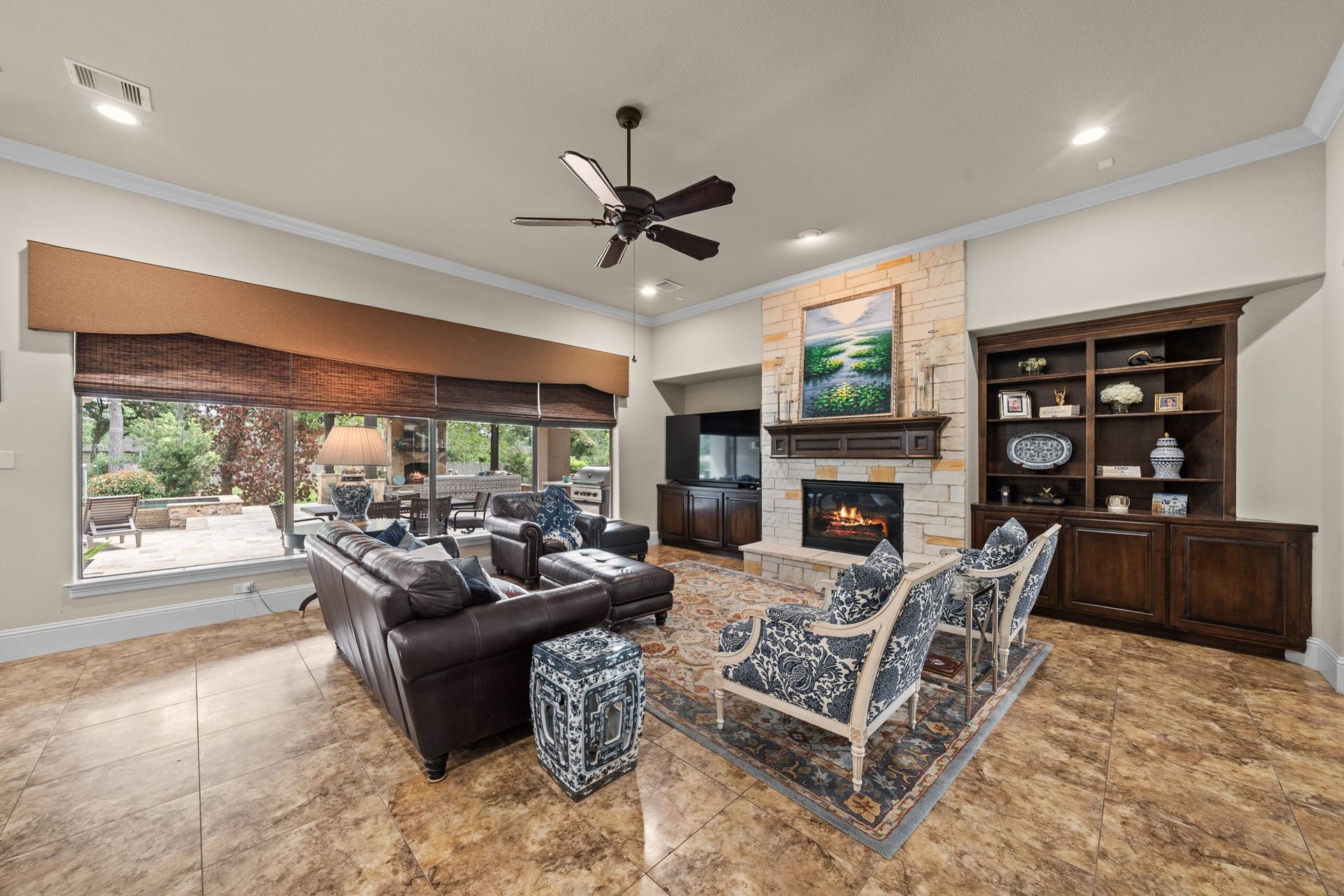 4426 Silver Jade Drive, Spring, TX 77386 Bathed in natural light and defined by grand proportions, the great room offers an unparalleled sanctuary for relaxation. A towering stone hearth commands the space, beautifully framed by built-ins and exquisite crown molding that highlights the soaring ceilings.