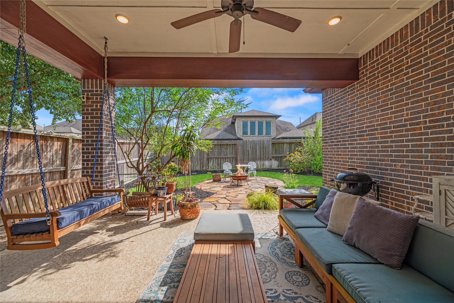 18203 Burnett Willow Lane, Cypress, TX 77433 Attractive covered patio with cozy swing and landscaping.