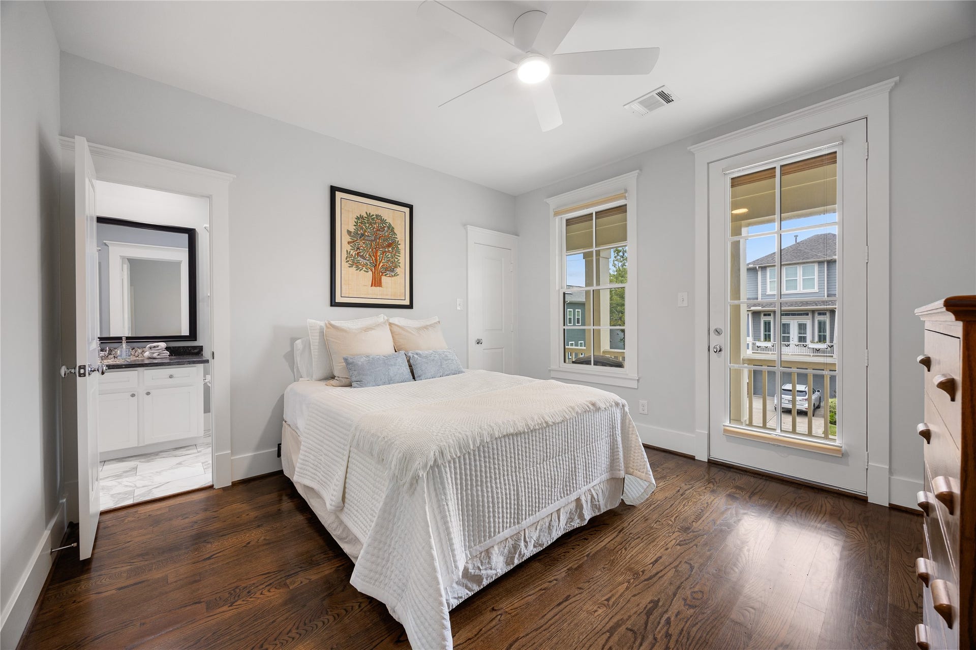 Bright secondary bedroom offers hardwood floors, ceiling fan & multiple windows.