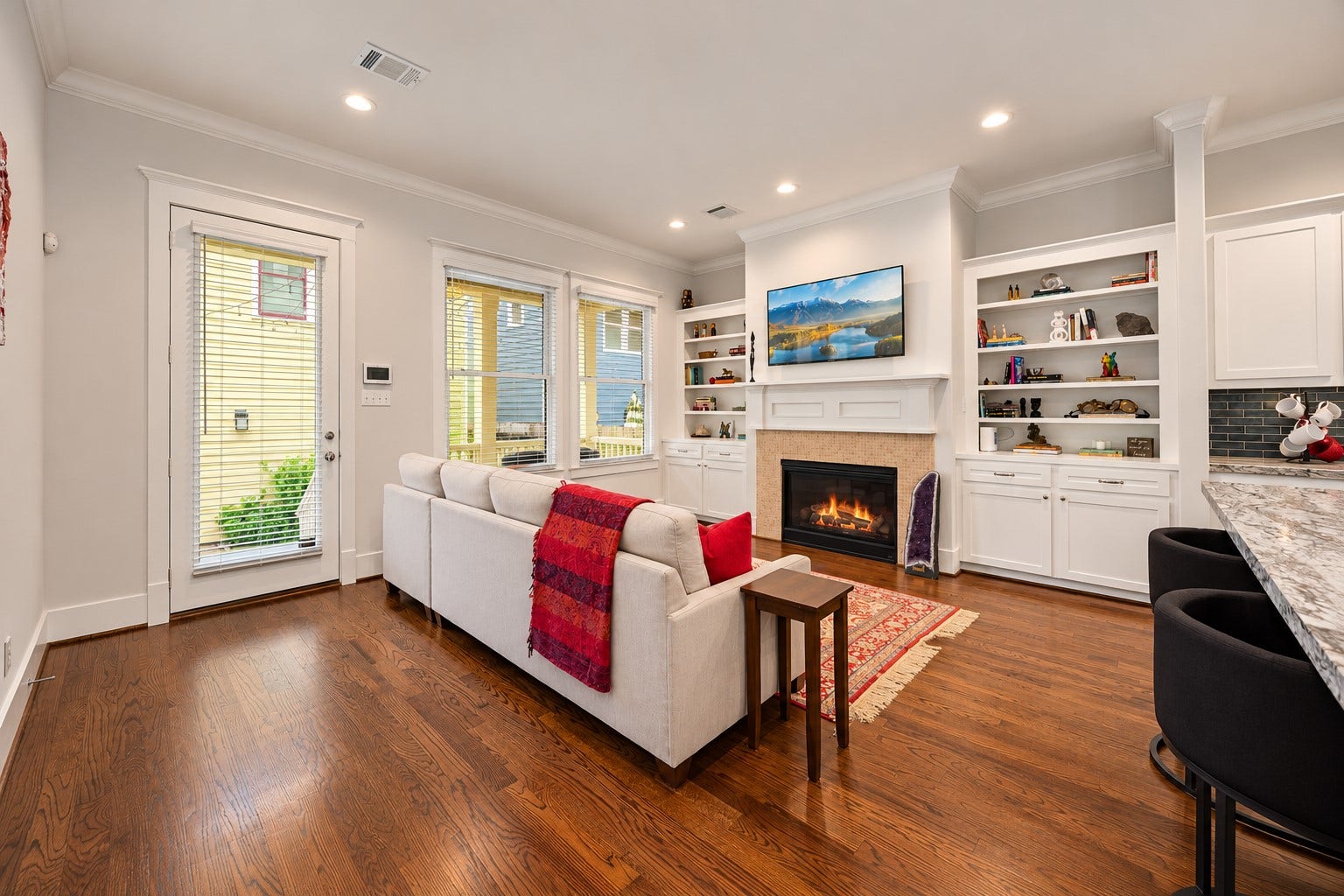 Another perspective highlights the family room's comfortable layout, hardwood floors & beautifully detailed fireplace.