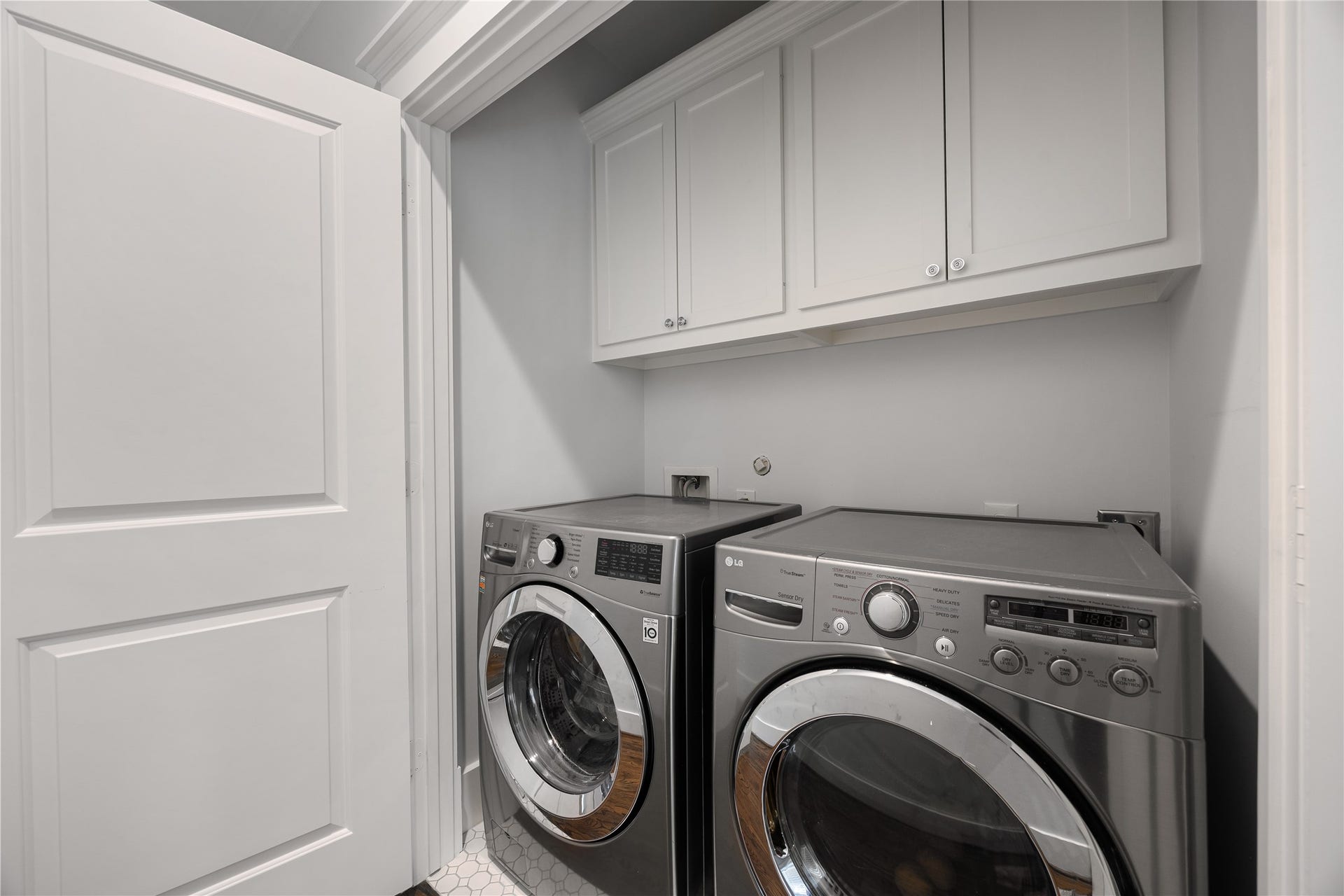 Convenient 2nd-floor laundry room includes cabinetry, storage & recent full-size washer and dryer.