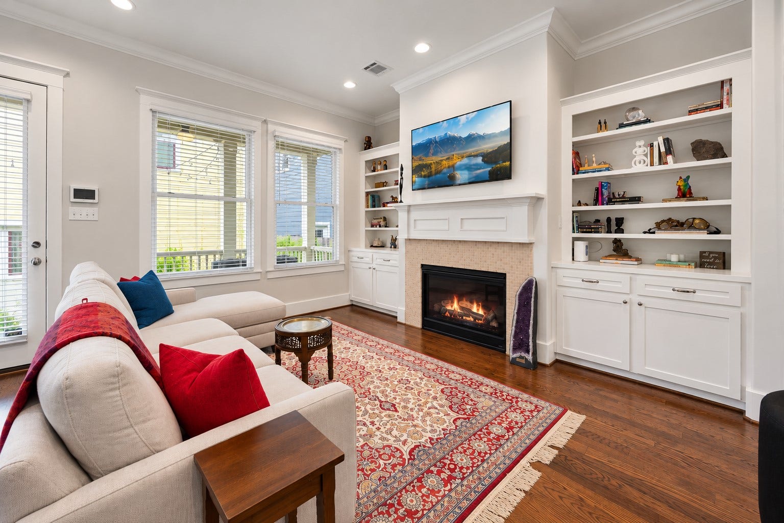 Inviting family room features a gas-log fireplace, custom built-ins, abundant natural light & an open connection to the kitchen.