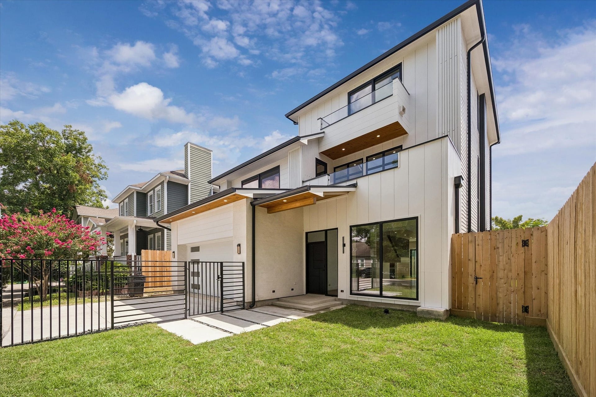 Striking modern home with refined lines, large windows, and a gated driveway, offering both style and privacy.