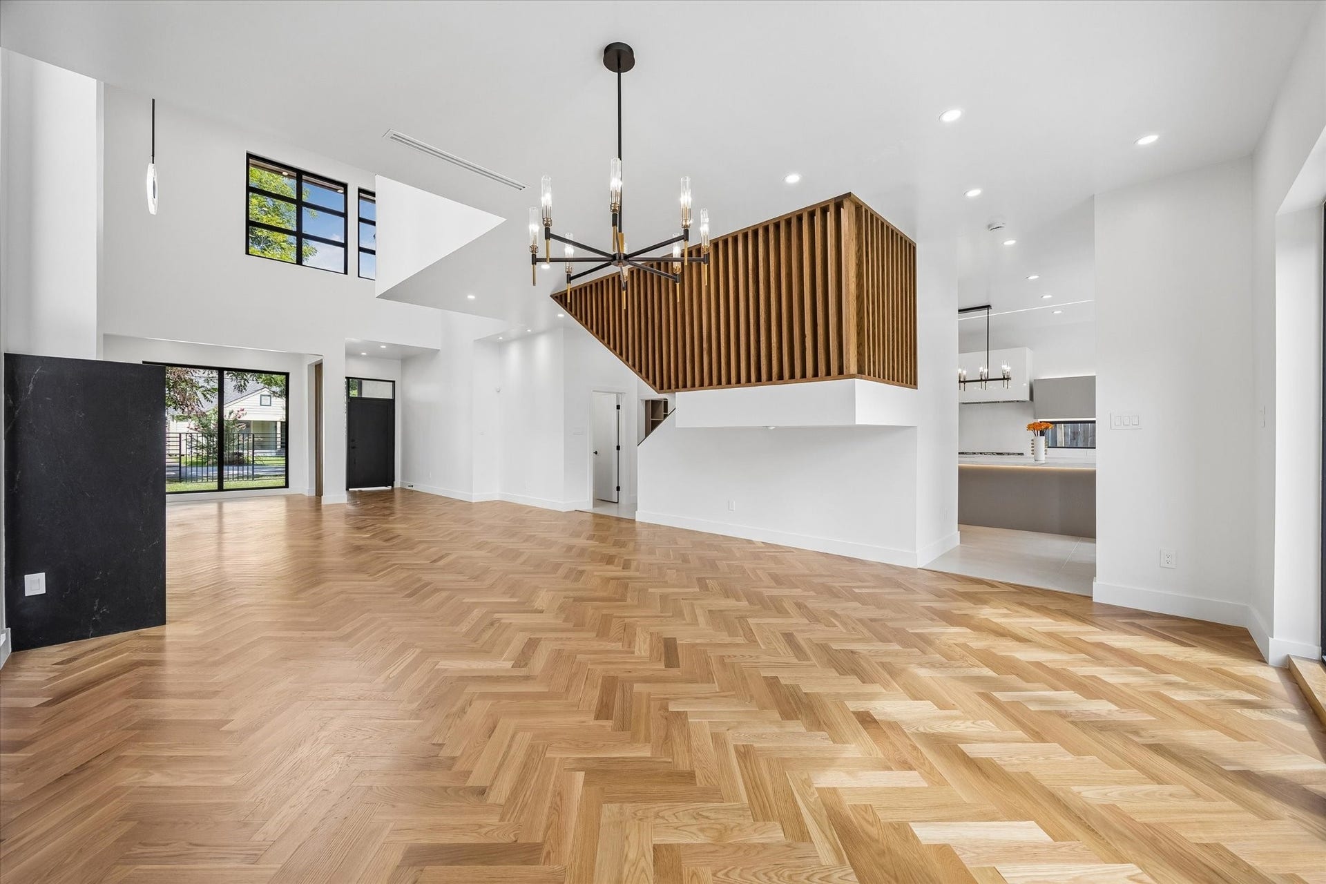 Floating staircase with warm wood slat detailing creates an architectural centerpiece.