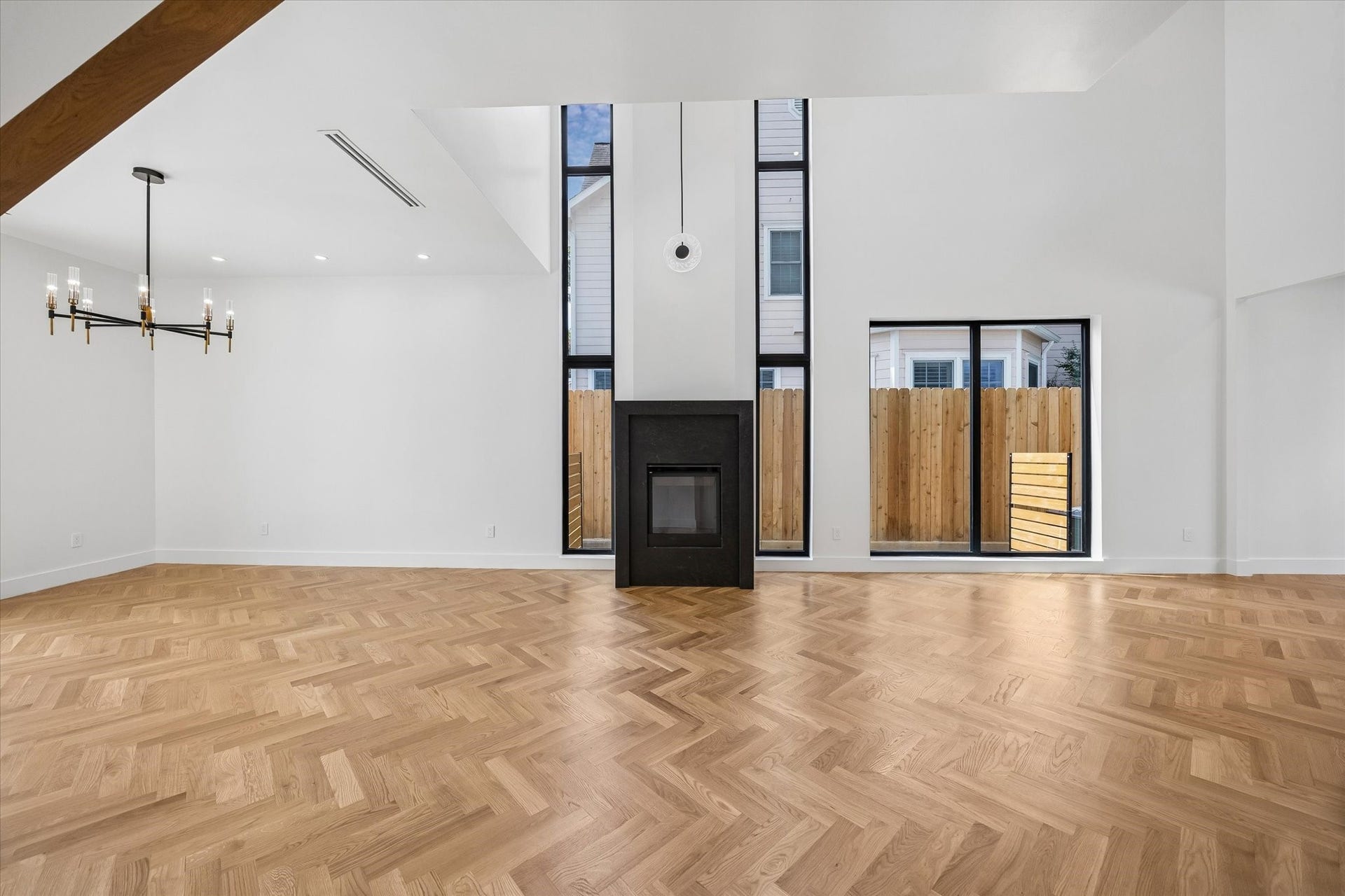 Striking floor-to-ceiling fireplace with an elegant oversized pendant serves as the focal point of the living room.