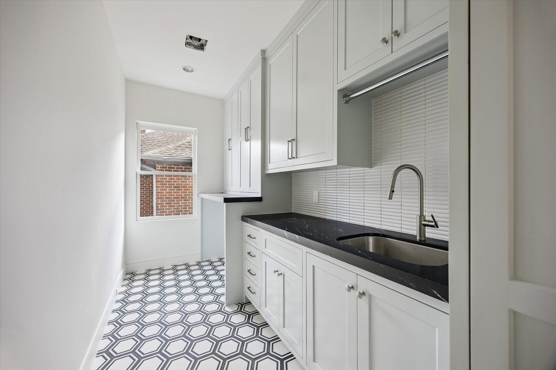 Large laundry room with abundant storage.  Includes marble countertop and convenient sink for hand washables.