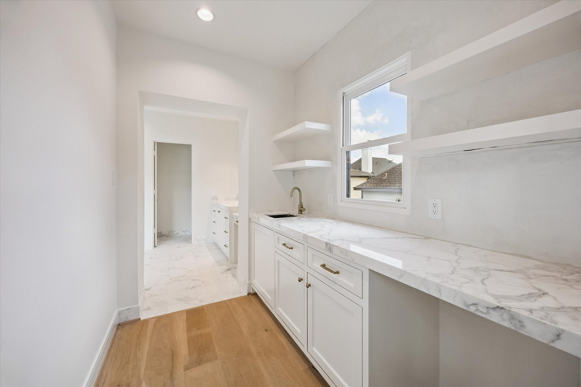 Additional cabinet and open shelf storage featured in the coffee bar between bedroom and bath.  Calacatta Gold marble countertop and hand plastered backsplash.