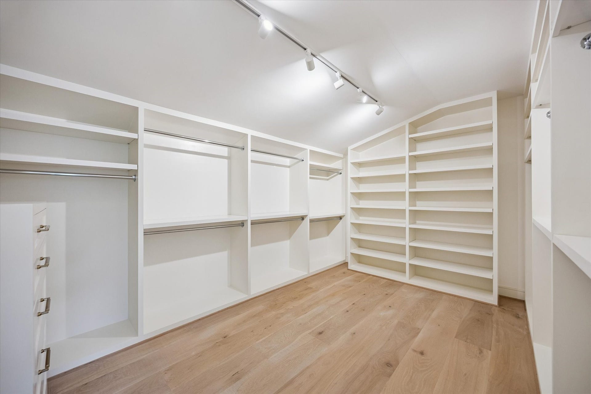 His and hers closets in primary include custom built-ins and track lighting.