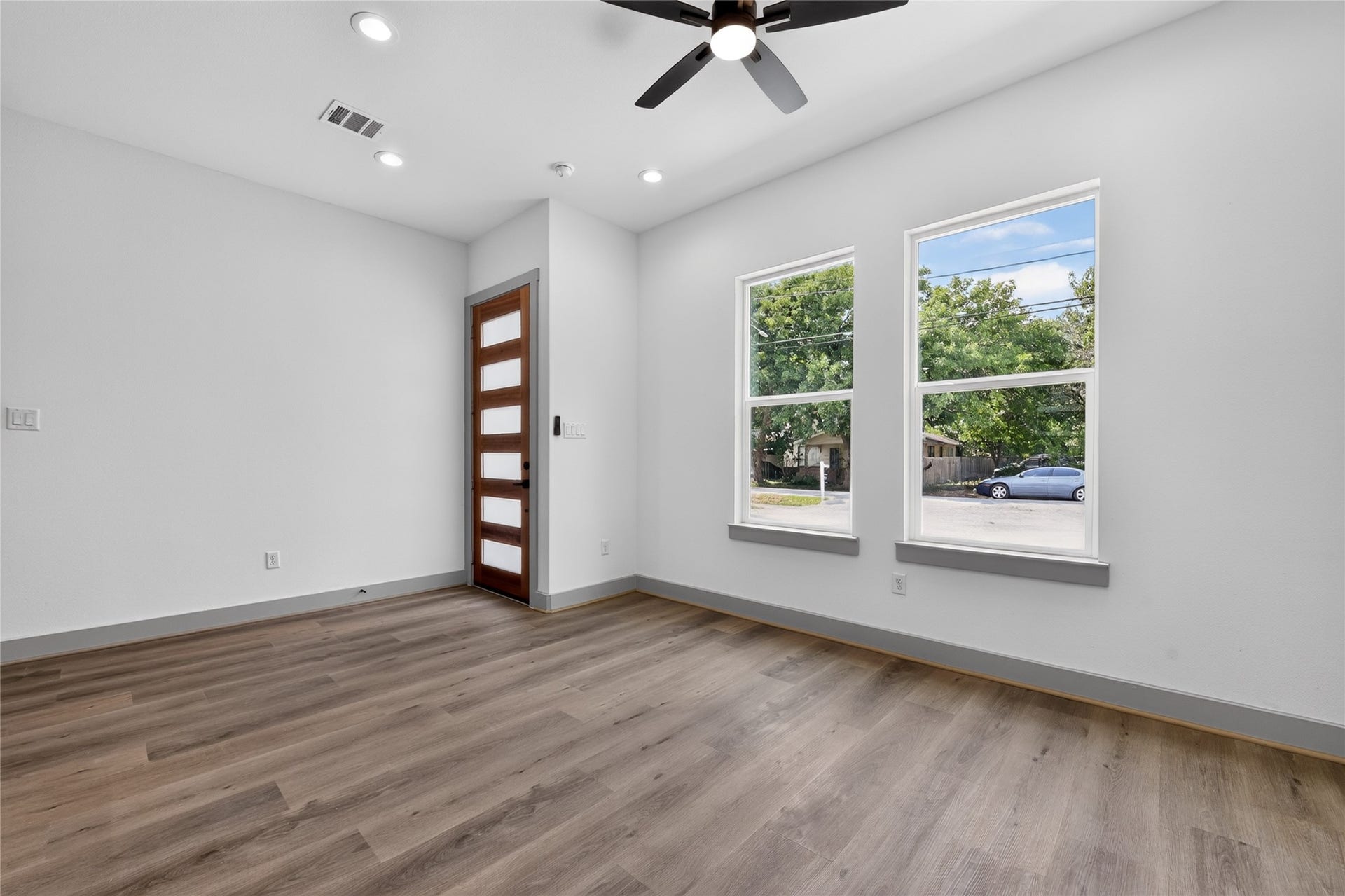Framed by windows, natural light pours into every corner, amplifying the room's open proportions and warmth.